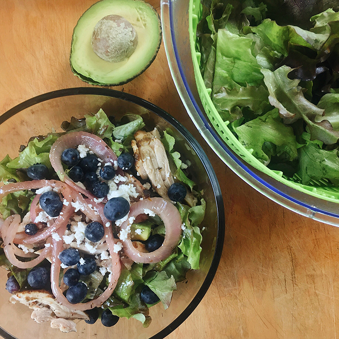 Sage and mustard roasted chicken thighs with marinated onions, avocado, organic blueberries and goat cheese atop greens from our CSA.