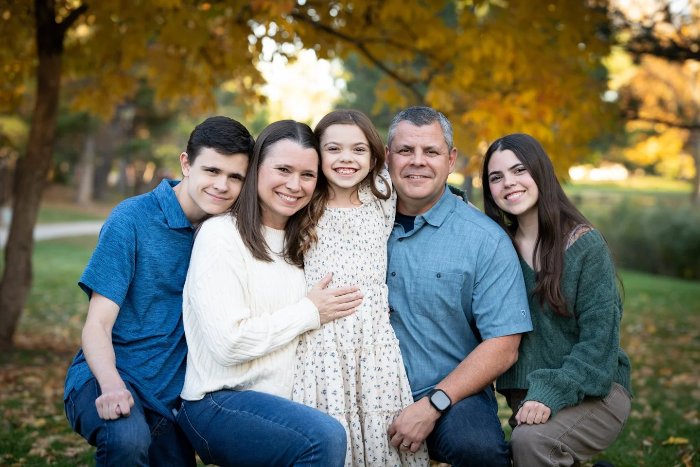 Family of five smiling together during a fall family photography session near Shaffer Elementary in Ken Caryl, Colorado