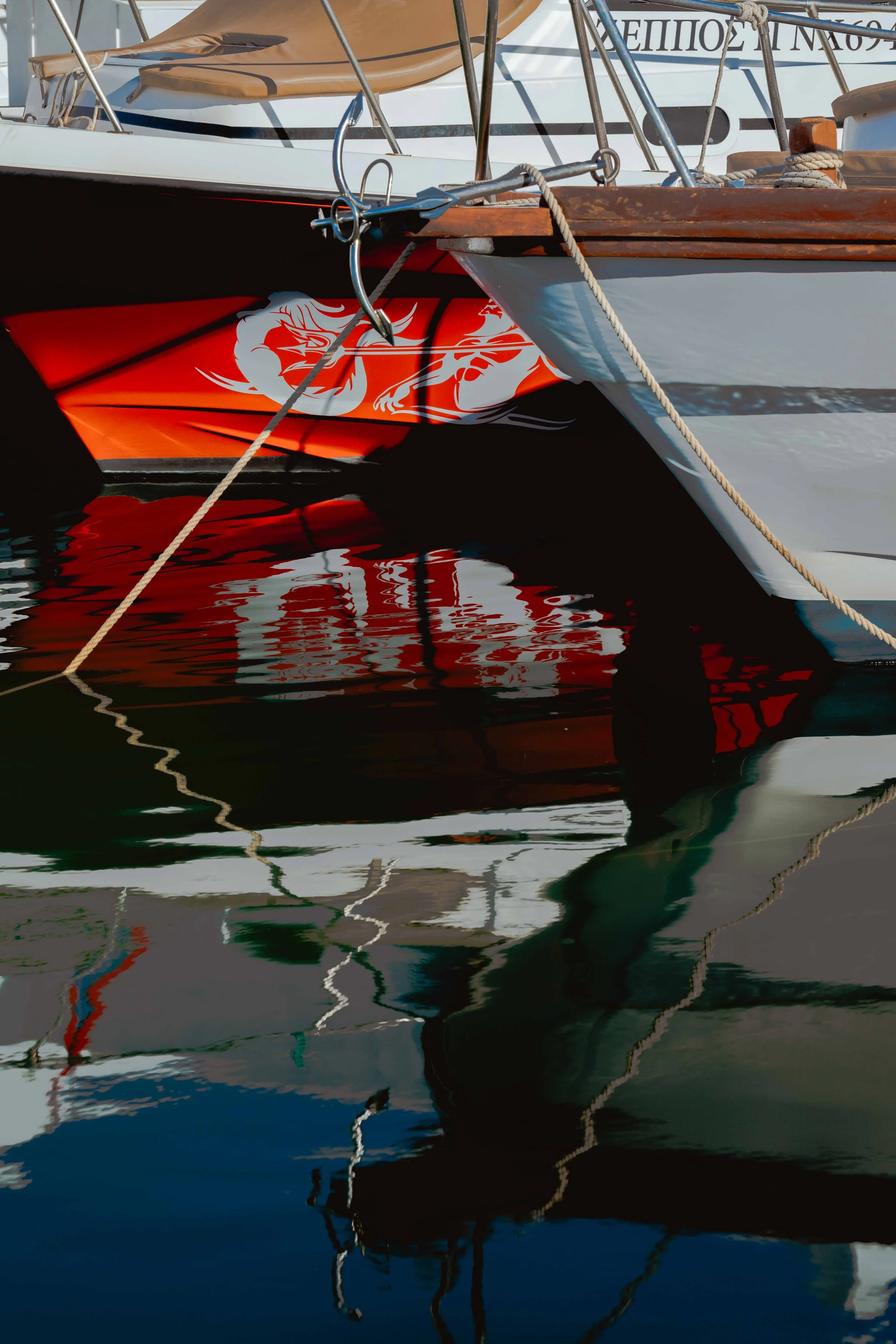 Close-up of boats moored at a dock, showing reflections in the water.