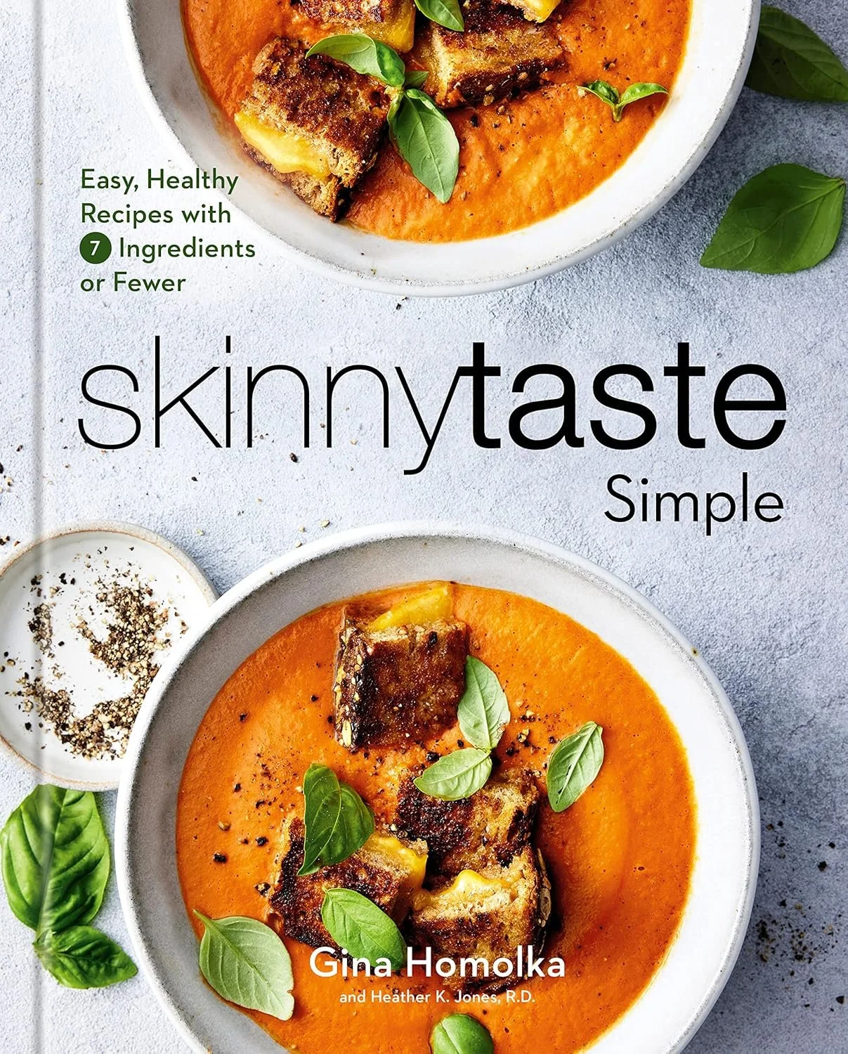 A cookbook cover titled "Skinnytaste Simple" with images of bowls of soup, likely tomato or roasted red pepper, garnished with basil leaves and topped with pieces of roasted vegetables or meat. The authors are Gina Homolka and Heather K. Jones, R.D.