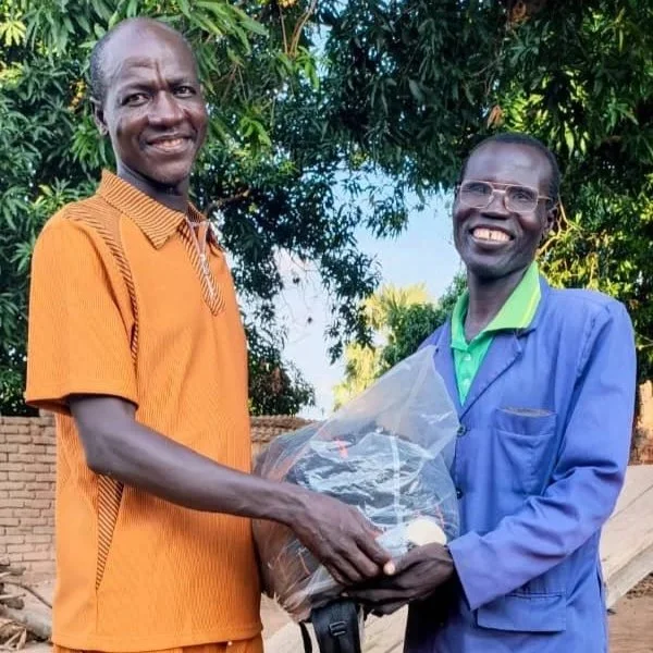 Ndilbe (L) gives film kit to Allarasem (R)