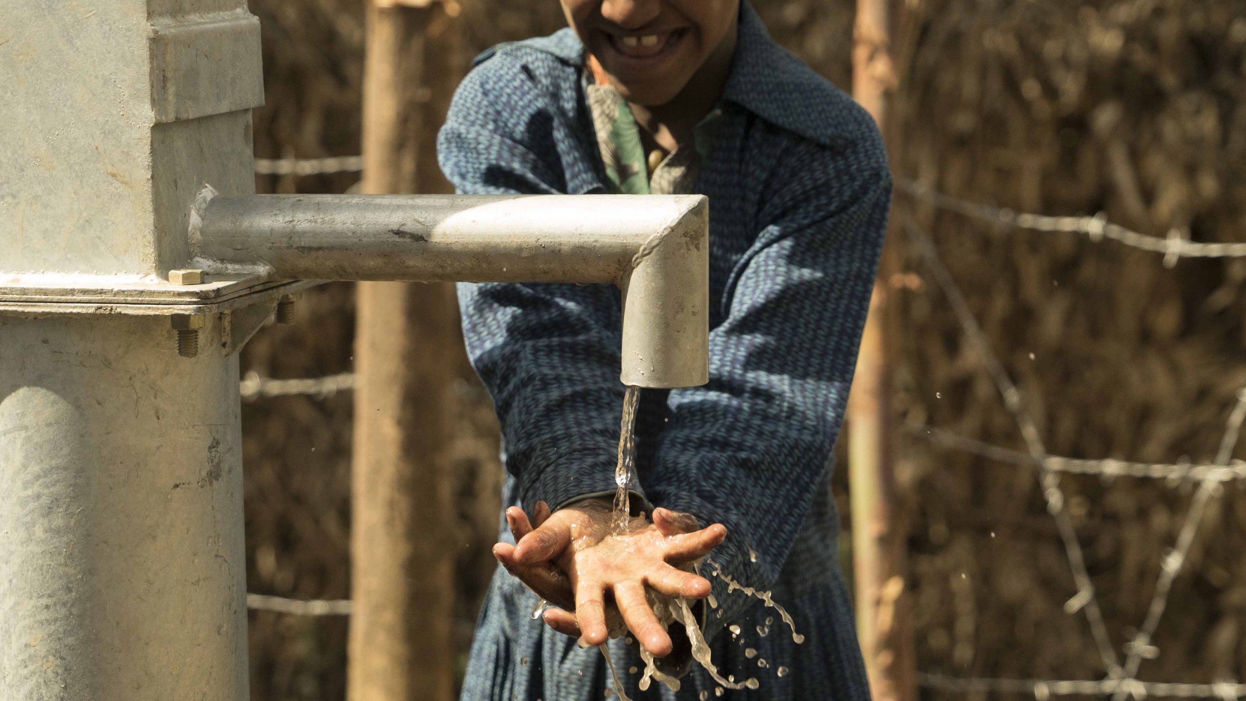 child washing with water from our project great shot.jpg