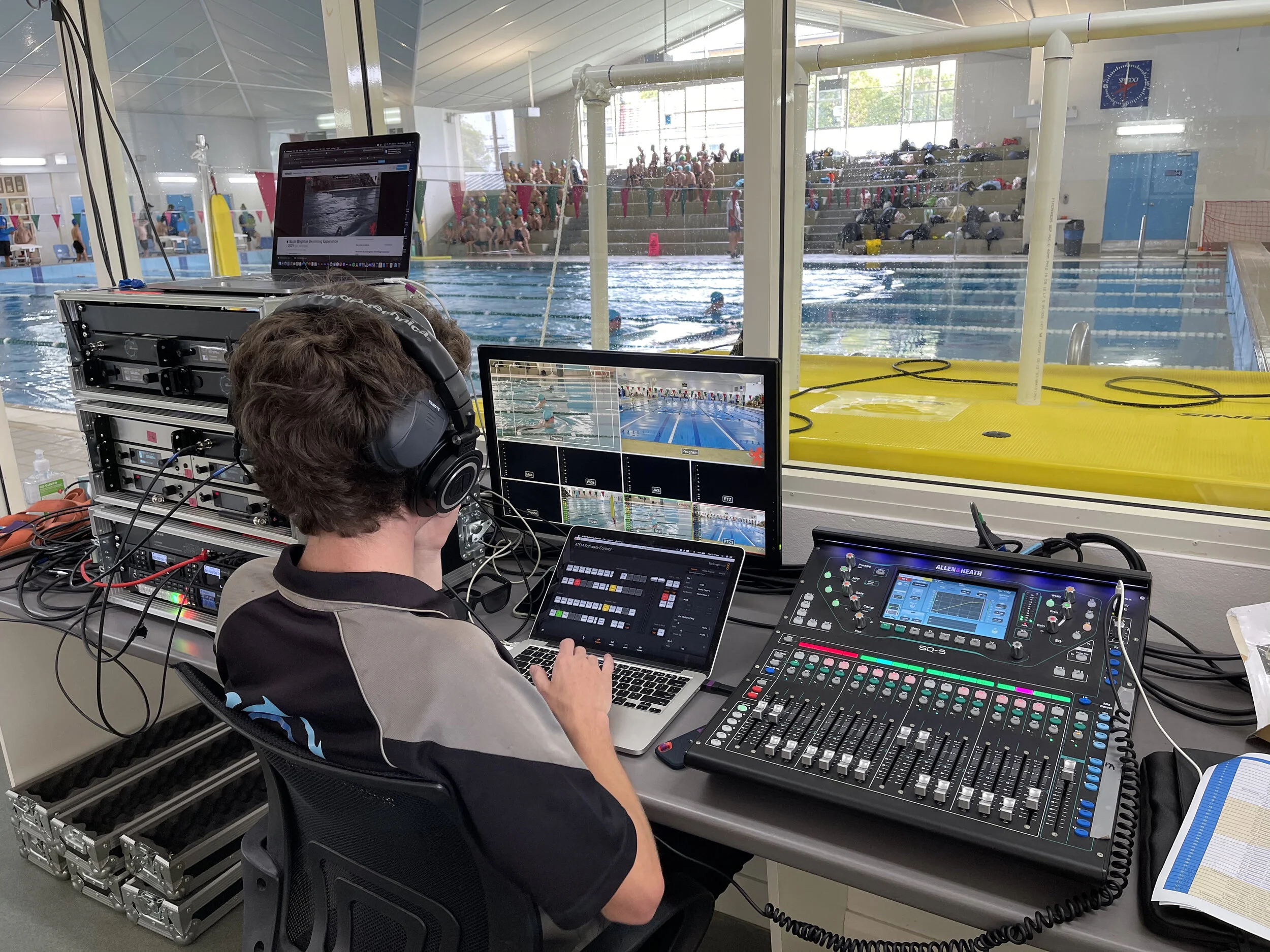 LKR operator live streaming a swimming carnival from a mixing and vision desk beside the pool