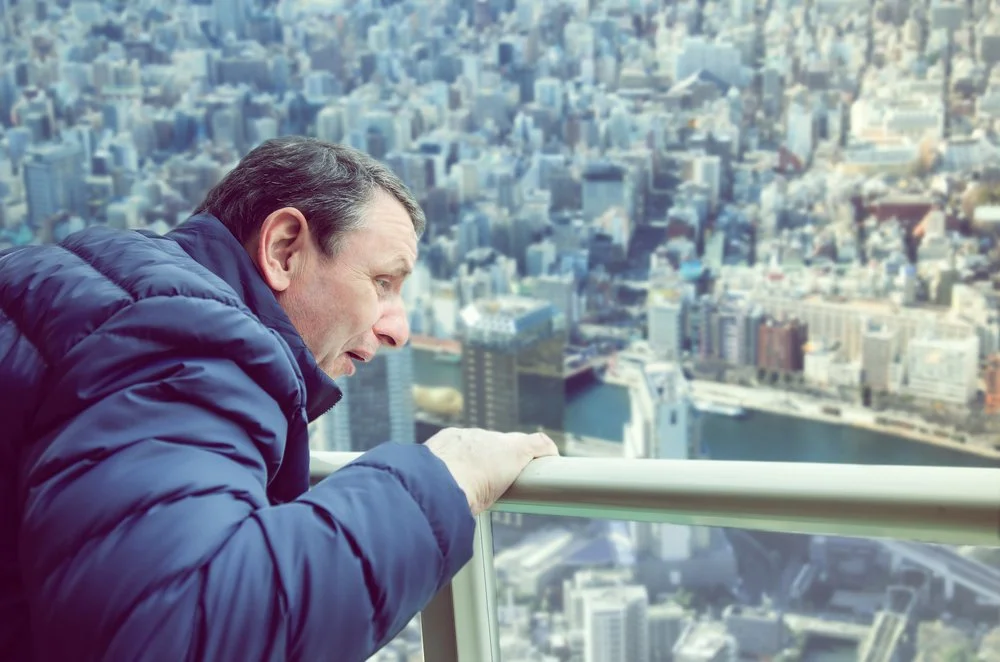 scared man looking over high railing