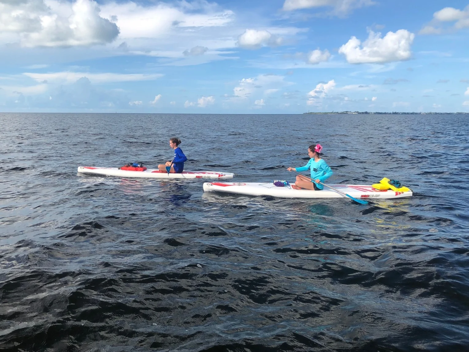 Sitting or kneeling on your board can reduce resistance when paddling in strong winds.