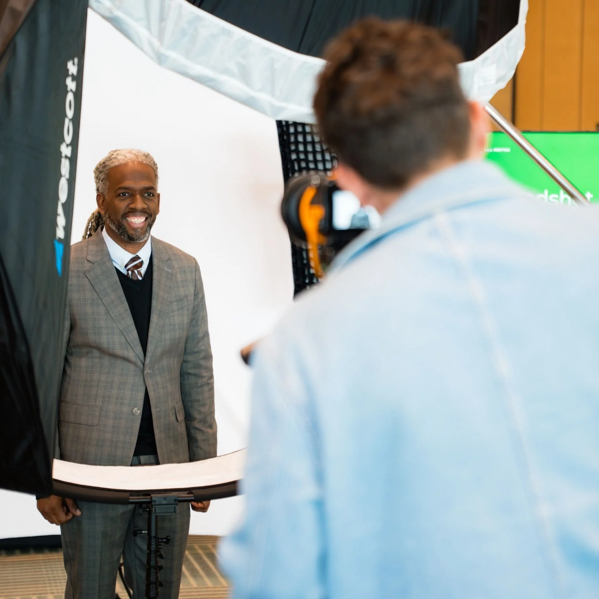 Professional photographer capturing corporate headshots at a busy Toronto event with a mobile studio setup.