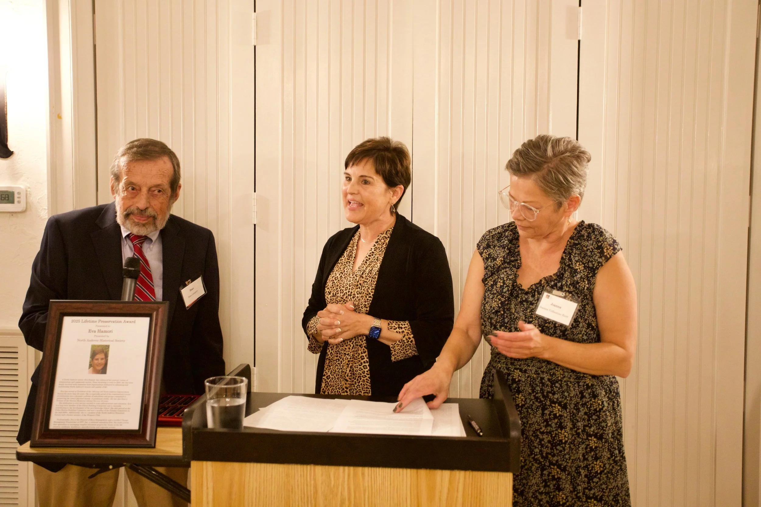 Stan Limpert (left), Chairman of the LPA Committee, and Joanna Collantine Kerr (right), Executive Director of the Historical Society, present the LPA award to Eva Hamori.