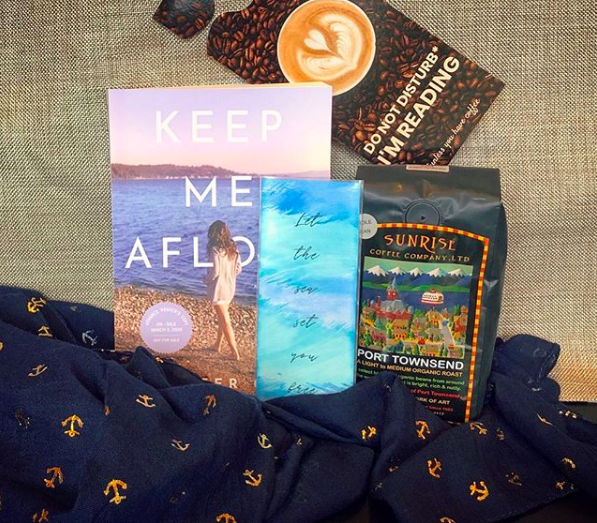 Instagram goodie basket: an advance copy of Keep Me Afloat, a navy scarf with gold anchor pattern, a bookmark, bag of coffee, and door hanger. ENTER HERE.