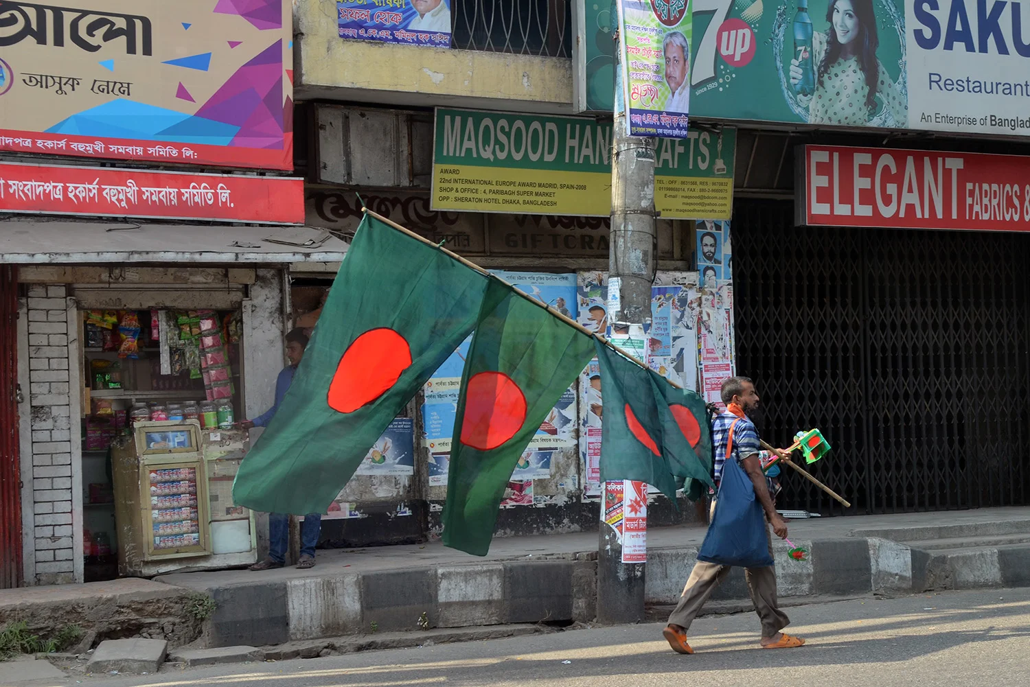 A man sells Bangladeshi flags ahead of Victory Day, celebrating the country's independence. Photo by Madeline Ewbank