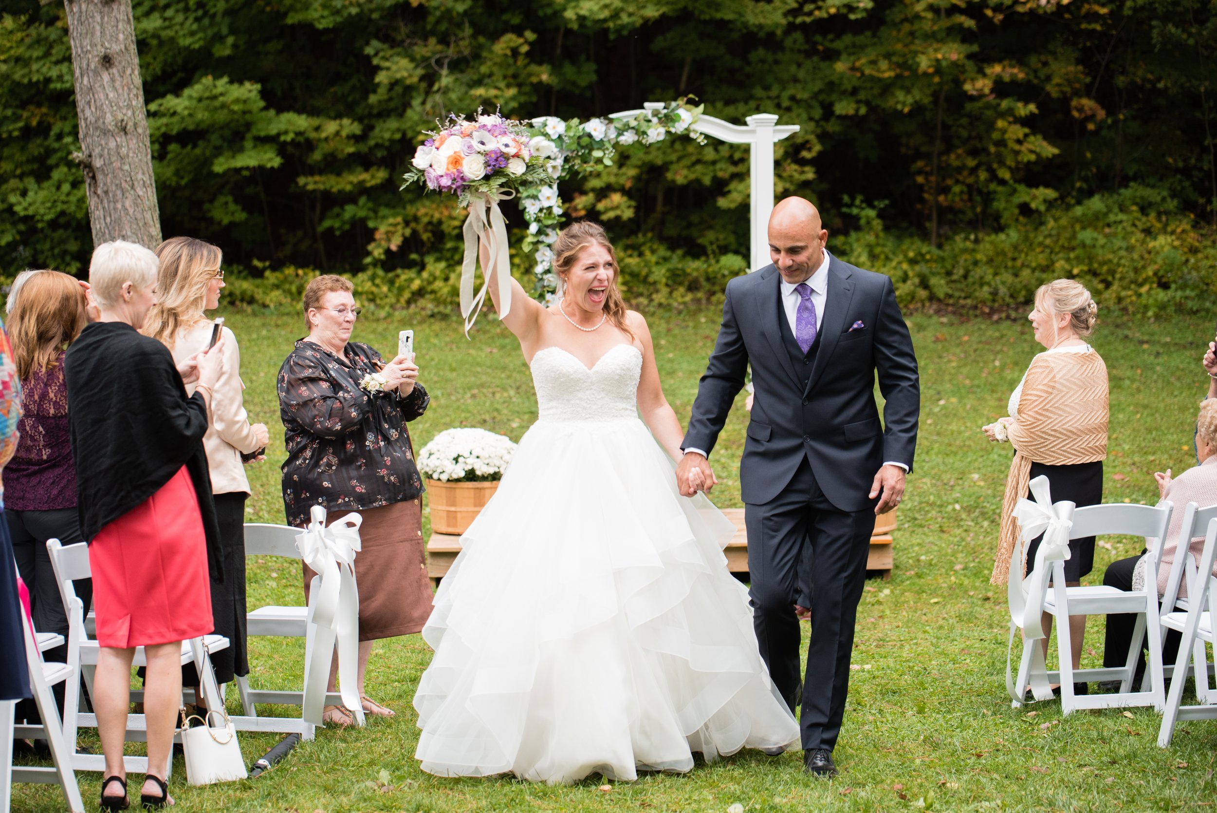 Bride celebrating with the groom after their outdoor wedding ceremony at Pathways on Pleasure Valley in Ontario.