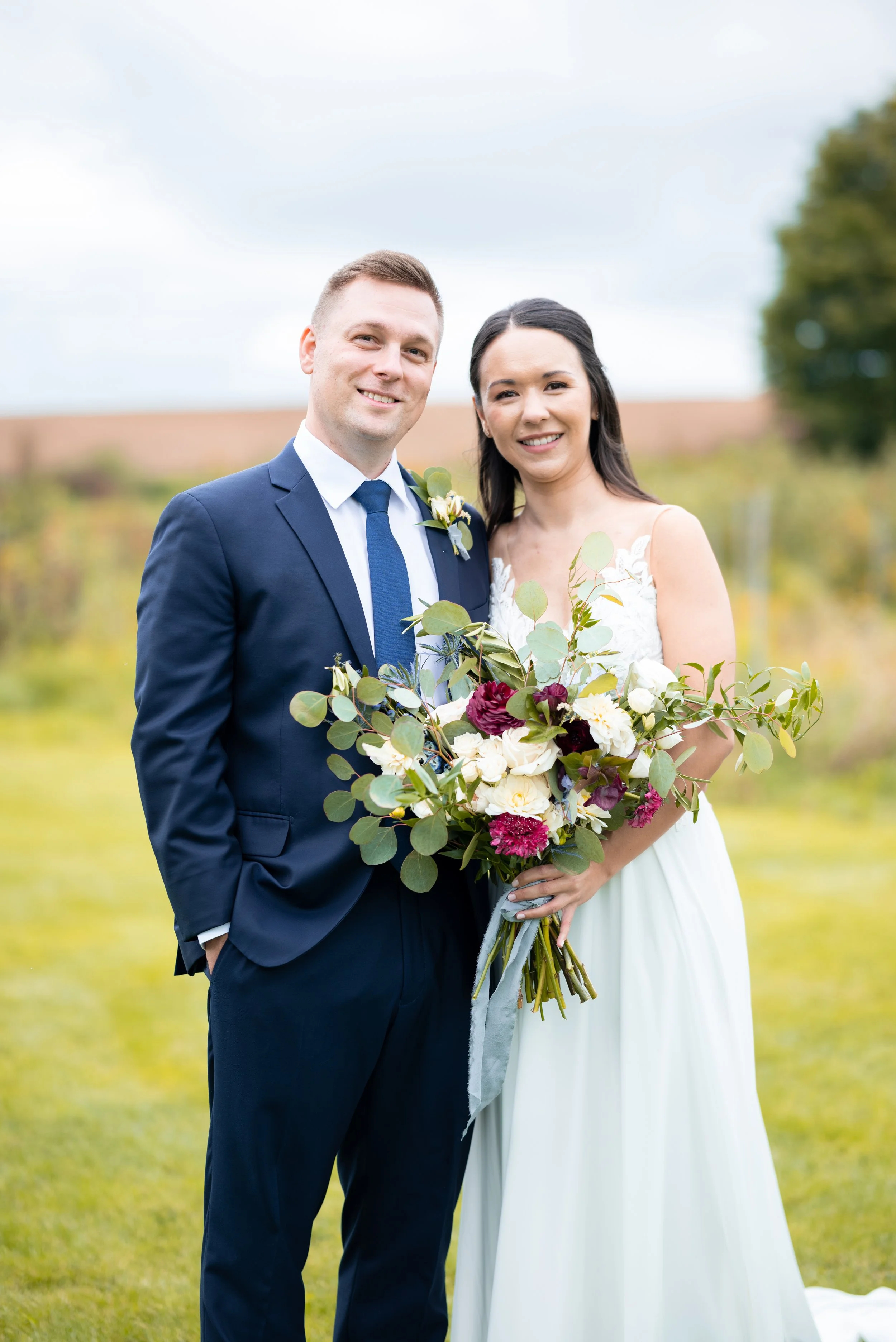 Bride and groom holding a bouquet at West Avenue Cider House in Freelton, Ontario