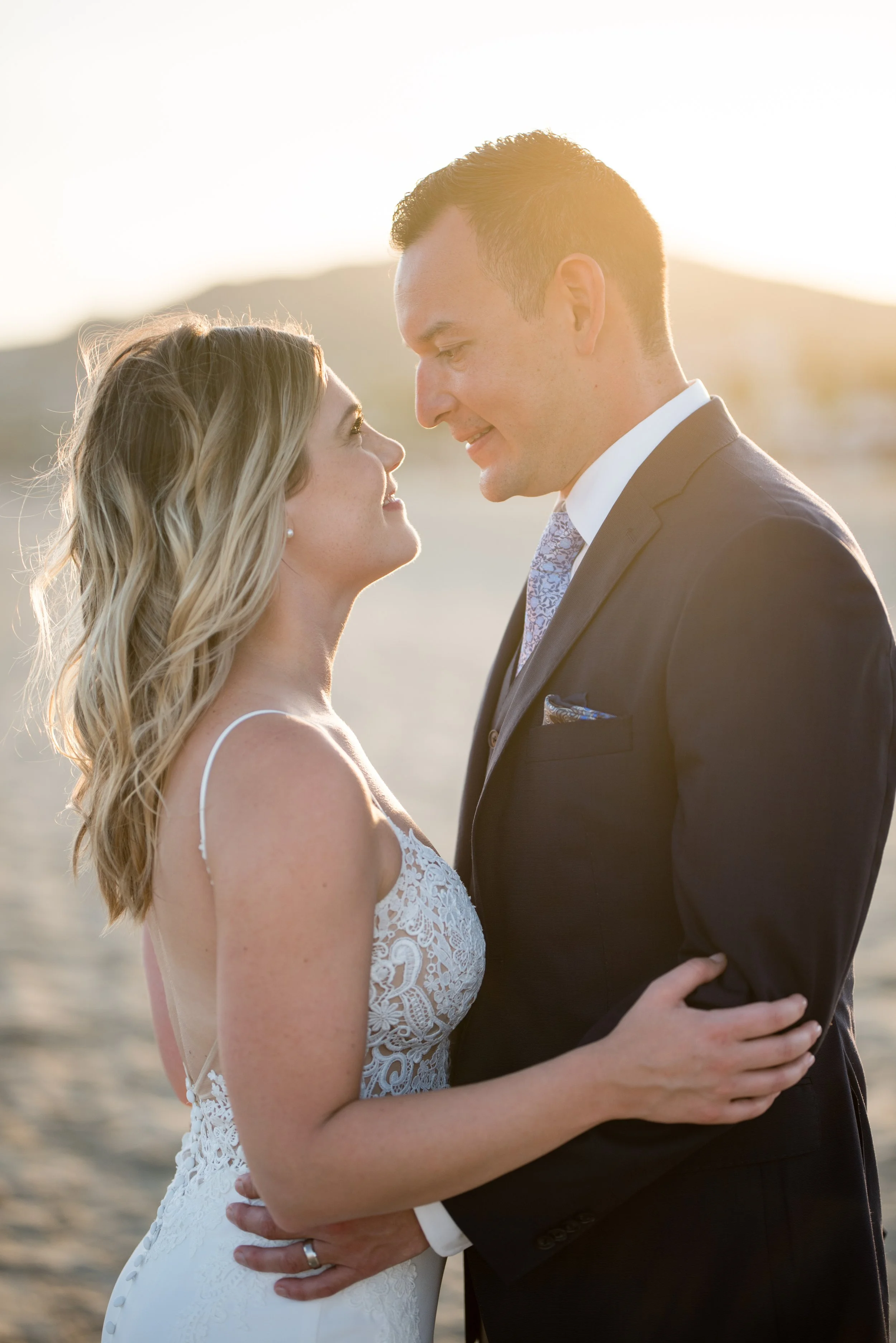 Bride and groom looking at each other during sunset portraits at their Los Cabos destination wedding