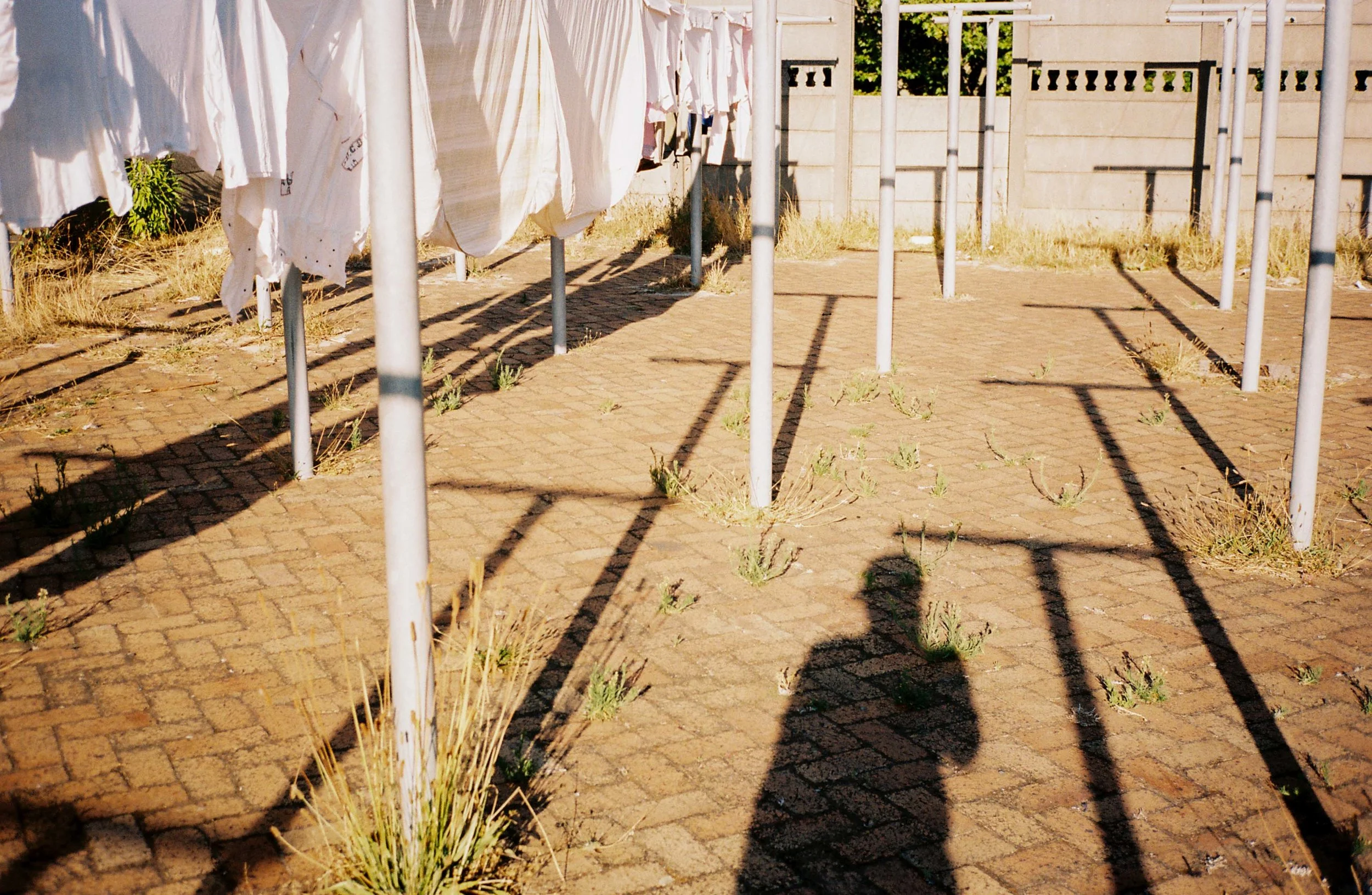DANIELS16 - Portrait of me in the military base - The washing line area was my escape as a child. I'd often zigzag with my bicycle around the poles whilst the fabric softener of clean clothes and sheets hit my face - 35mm.jpg