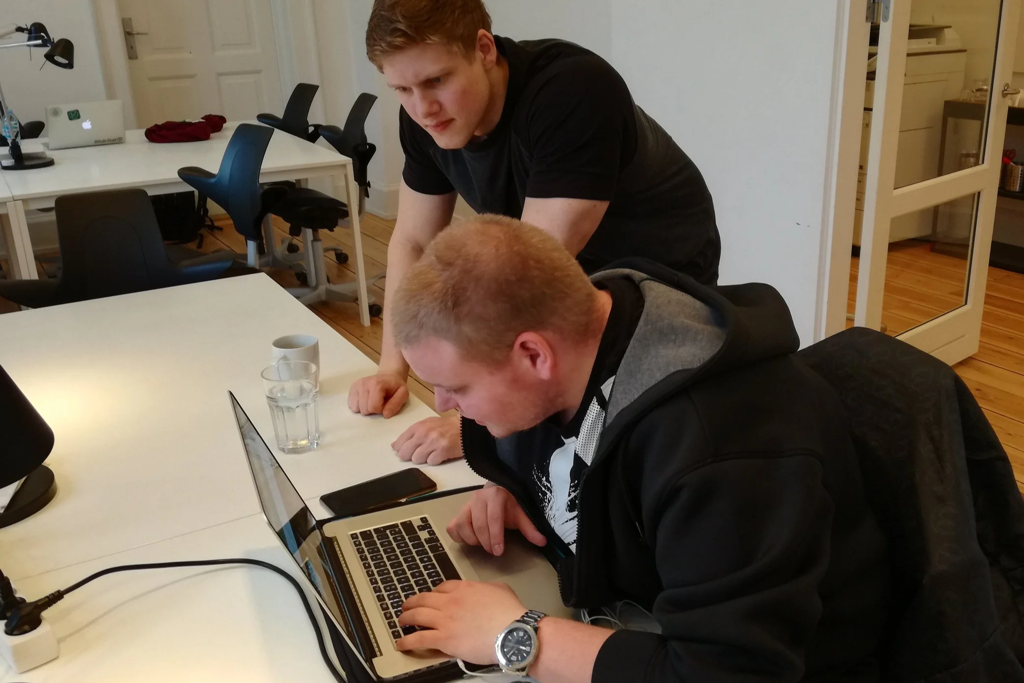 Her ses Rasmus som står ved siden af Lasse. Lasse sidder med en computer og tjekker en hjemmeside for hvor tilgængelig den er for ham som en bruger med nedsat syn.