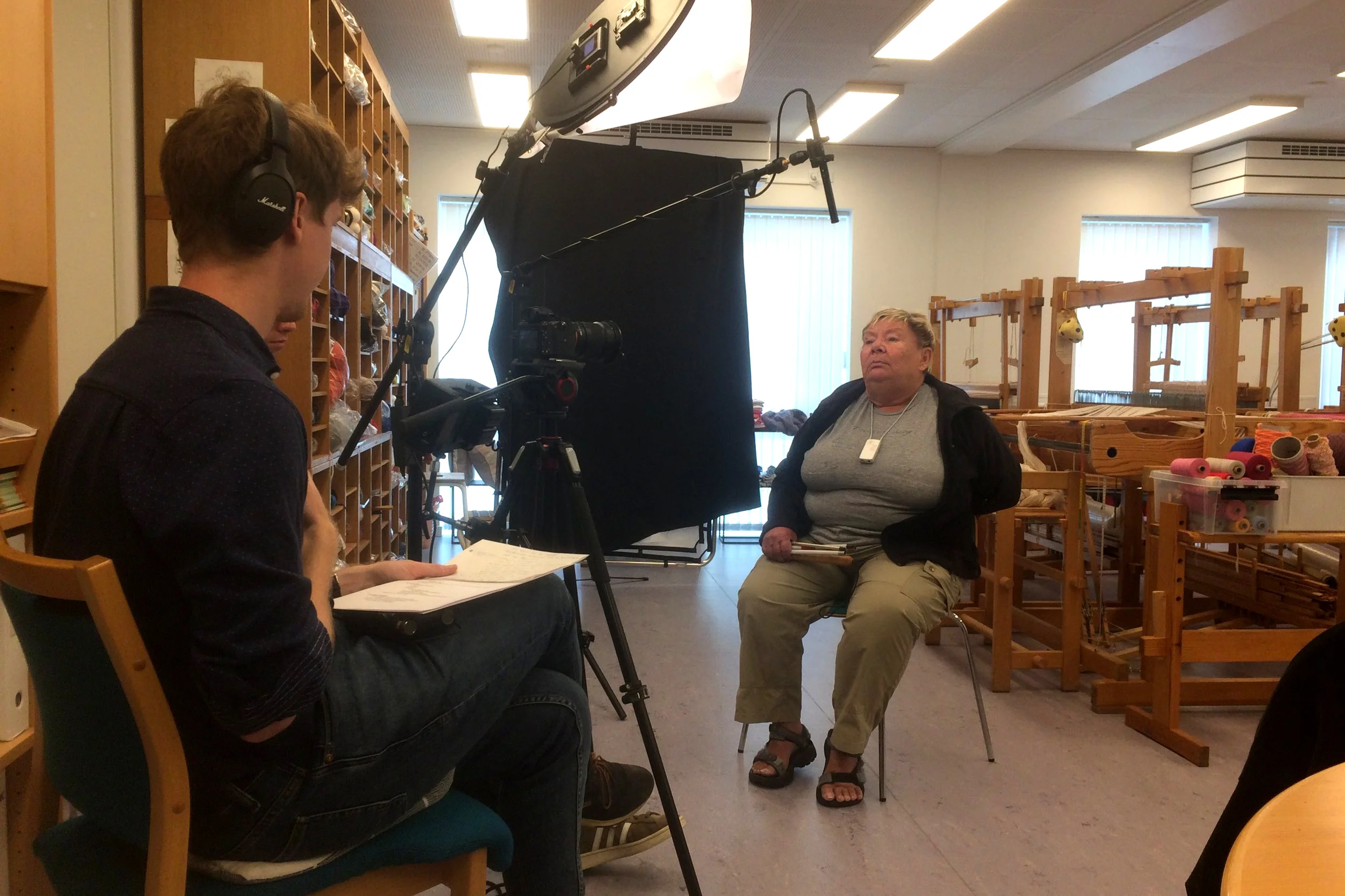 Her ses Birte, som er i gang med at blive interviewet af en mandlig projektmedarbejder. Interviewet finder sted blandt væve og garn i et aktivitetscenter.