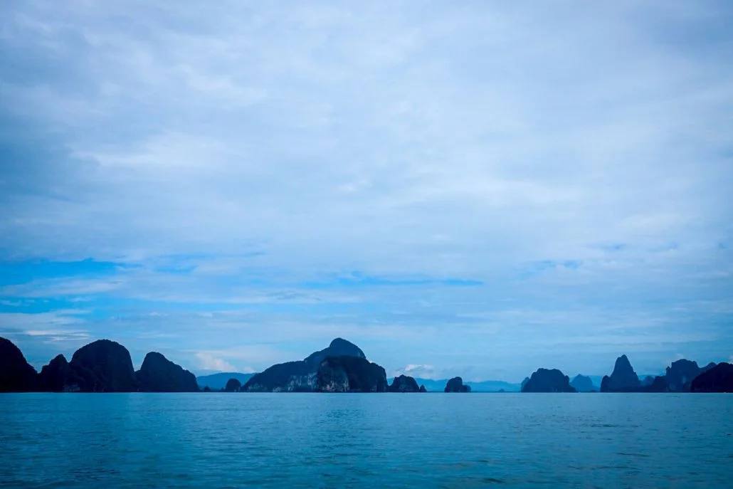 As the sun sets in Thailand the emerald greens give way to a sea of cool, glassy blues.