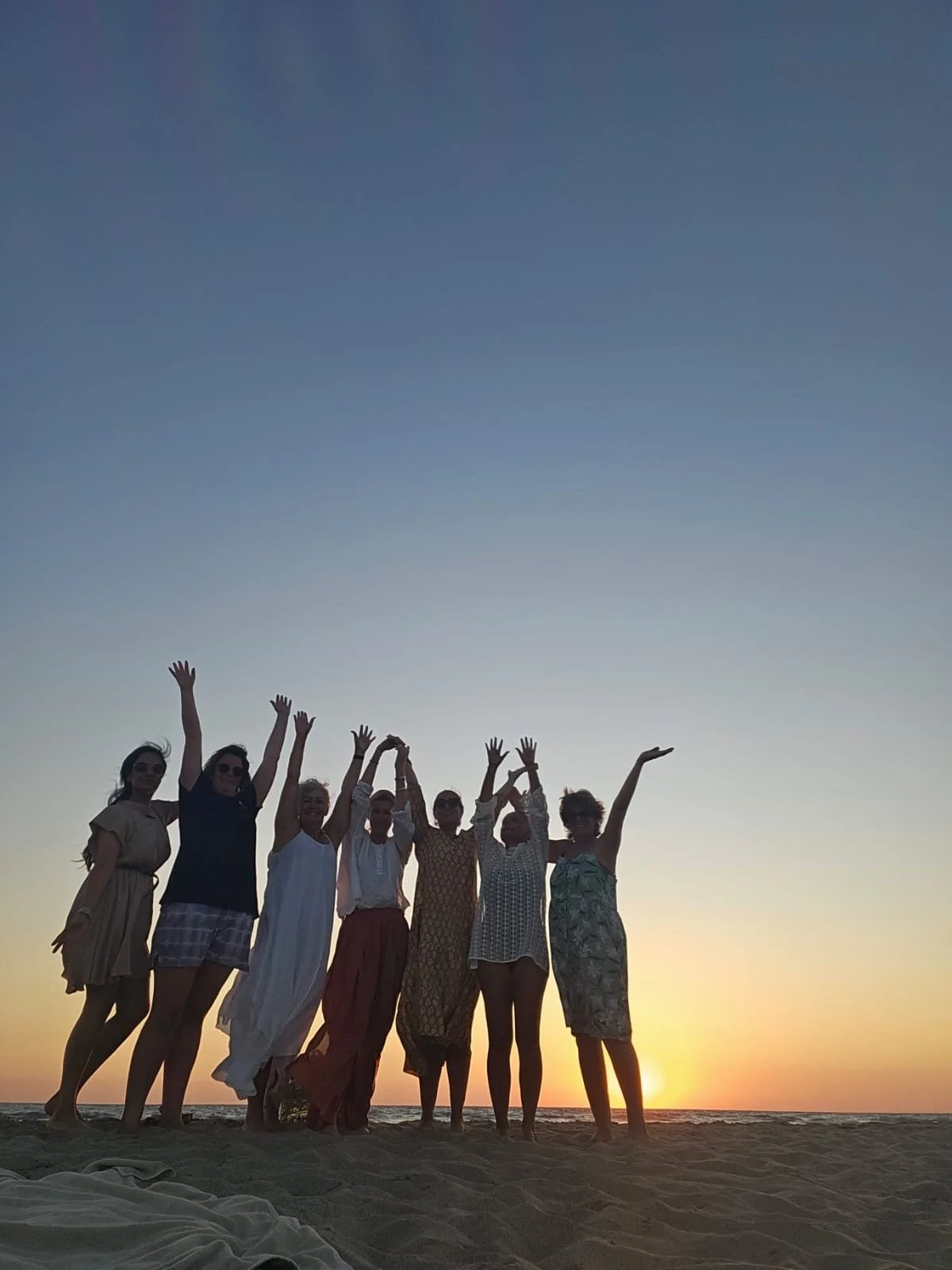 Group on the beach with hands up.JPG