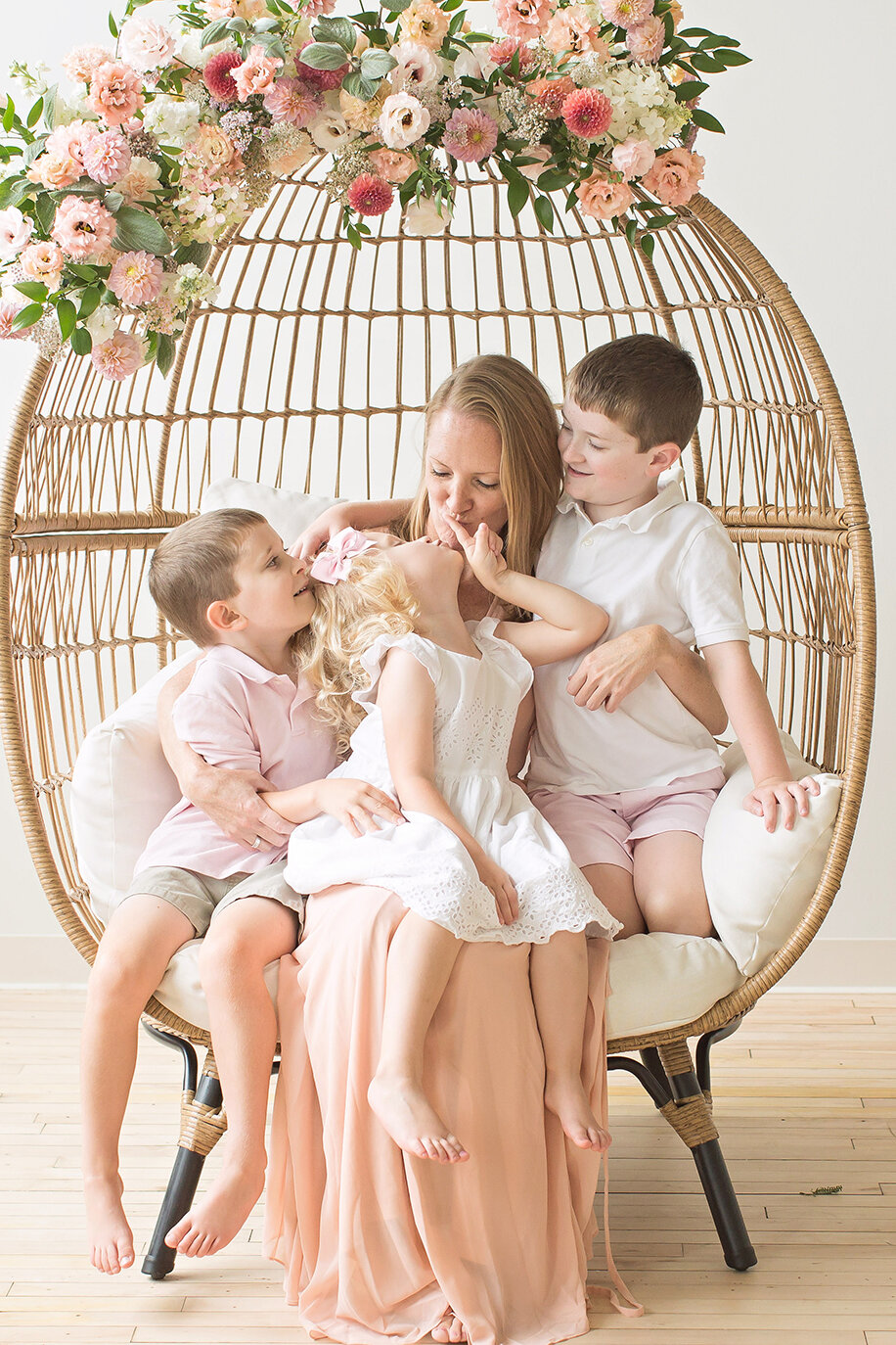 Mom sitting with kids in floral chair Philadelphia newborn photographer
