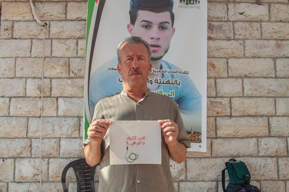  Bassem Tamimi, in front of a picture of his son who earlier this year was arrested for throwing stones at Israeli soldiers and served a prison sentence, Nabi Saleh, Palestine 