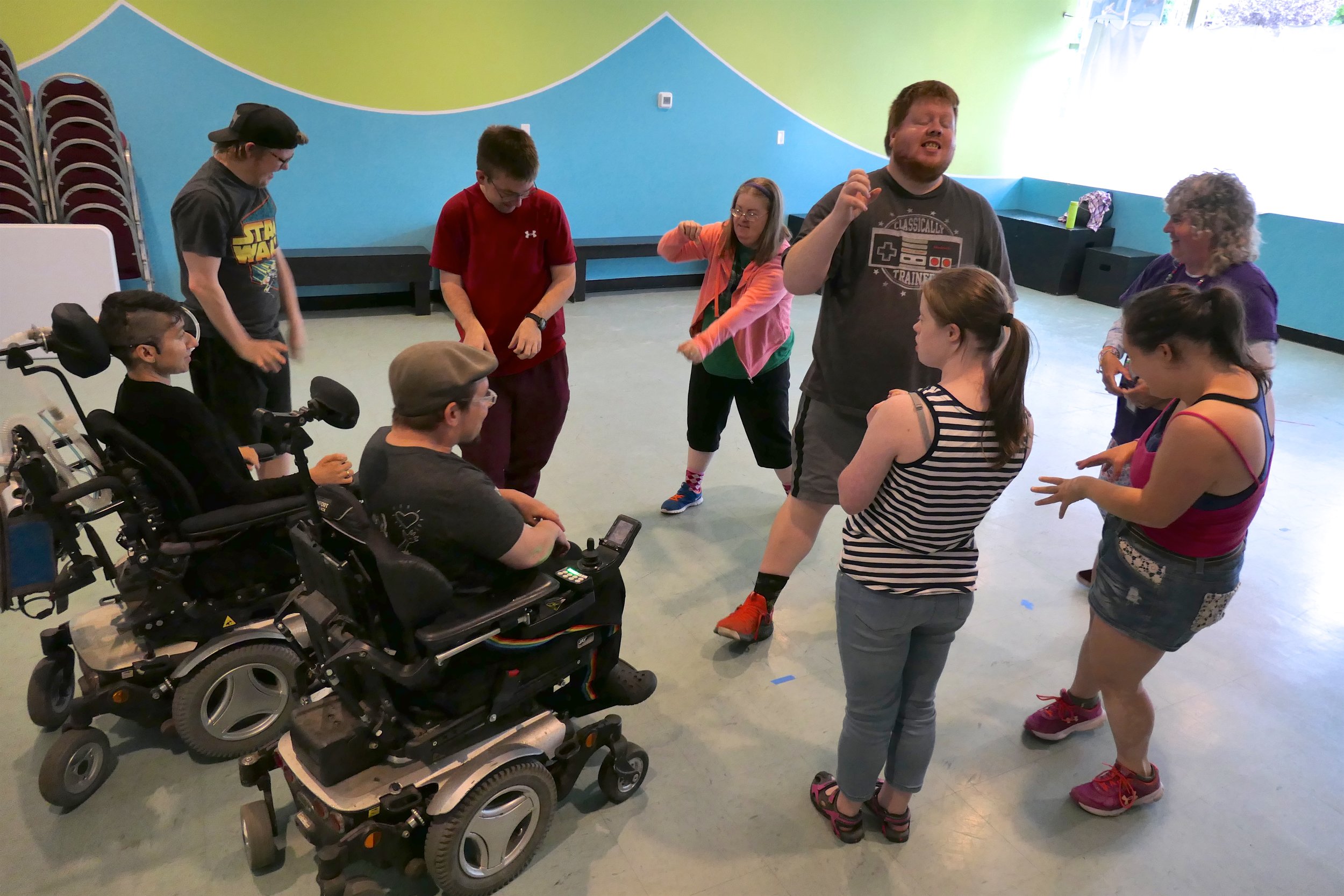 Group of people in a room, some use wheelchairs