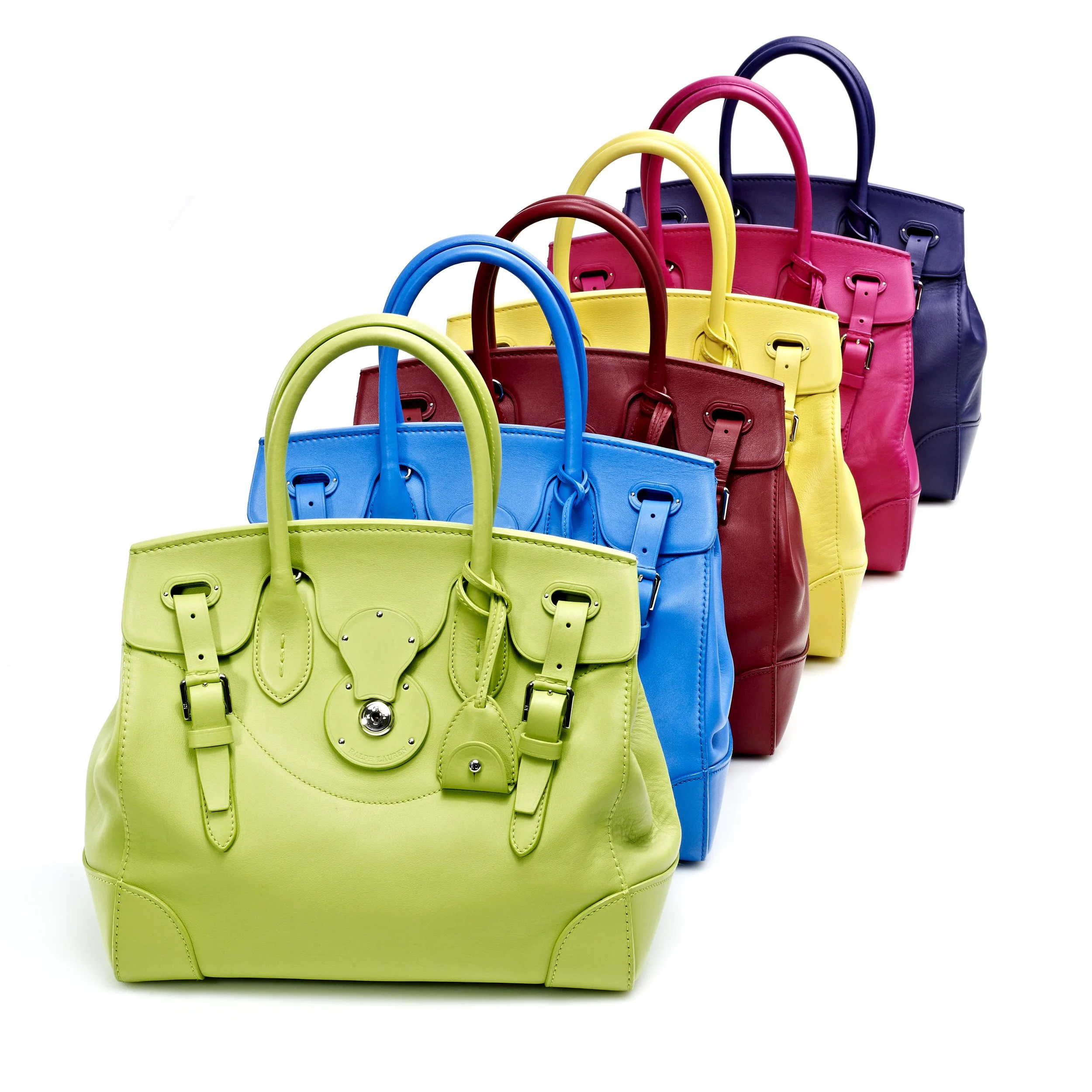 Colorful handbags arranged in a row, featuring lime green, blue, red, yellow, pink, and navy blue colors.