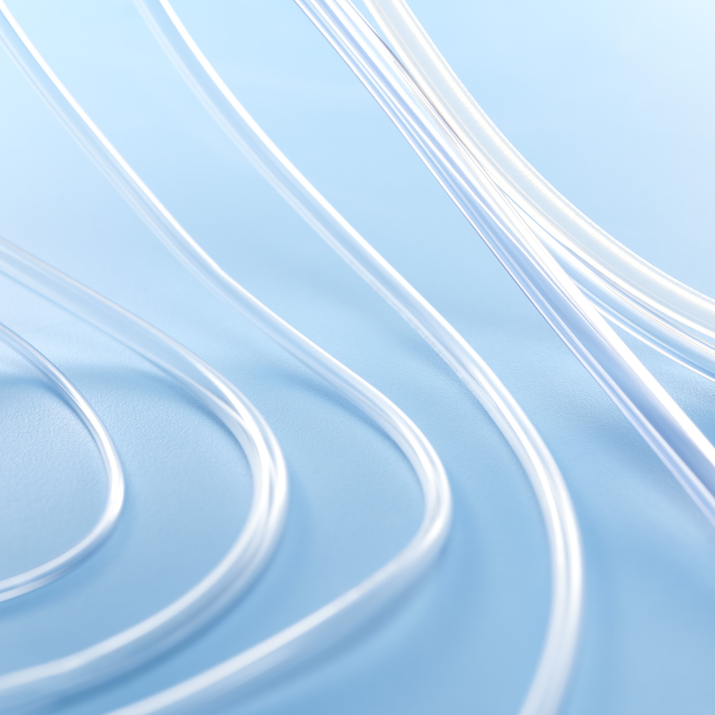 Close-up image of transparent plastic straws arranged in parallel on a light blue background.