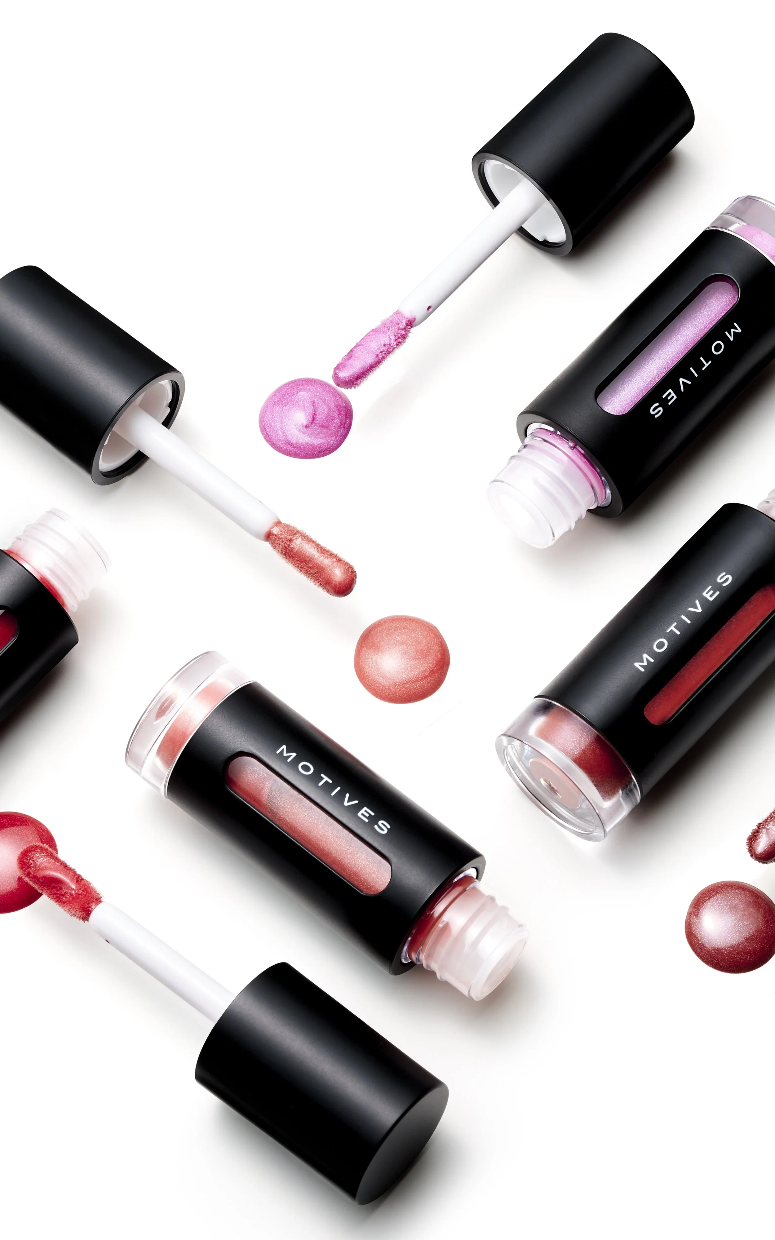 Liquid lipstick tubes with applicators and swatches of pink and coral shades on a white background.