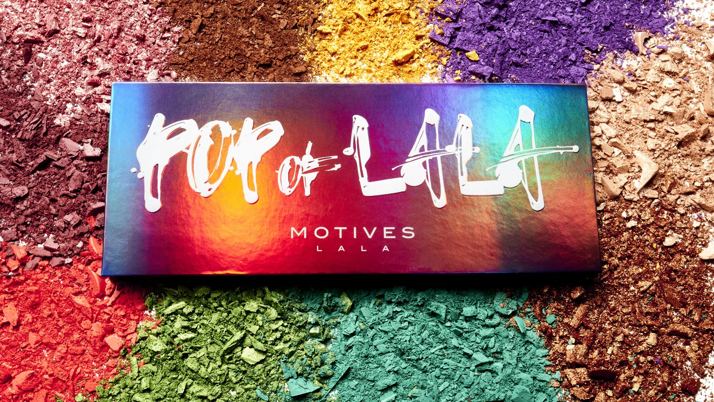 Colorful Euphoria Eyeshadow Palette with the words 'Euphoric' written in white on the front, resting on a background of vibrant, multicolored powdered pigments.