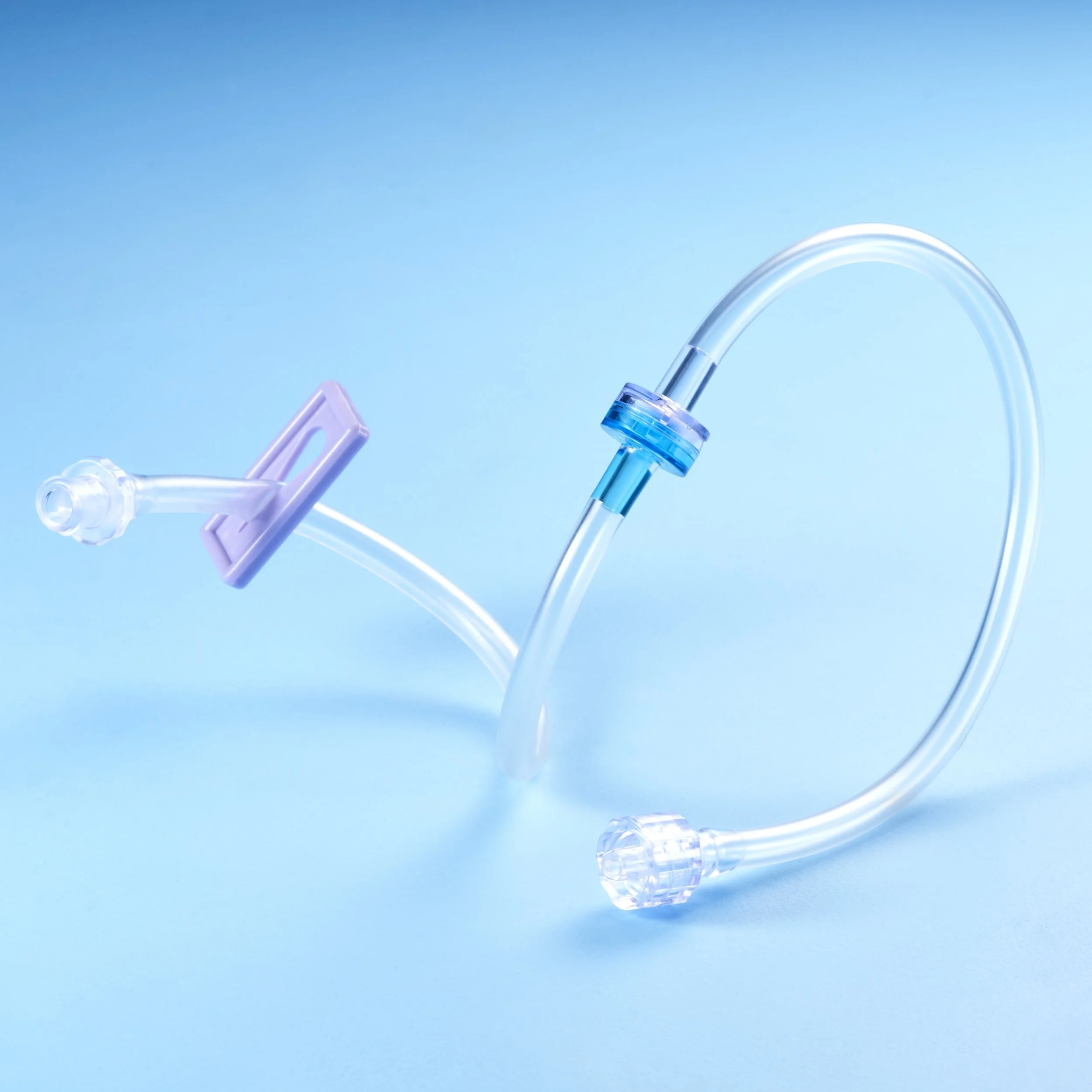 Close-up of a medical intravenous (IV) drip set against a blue background.