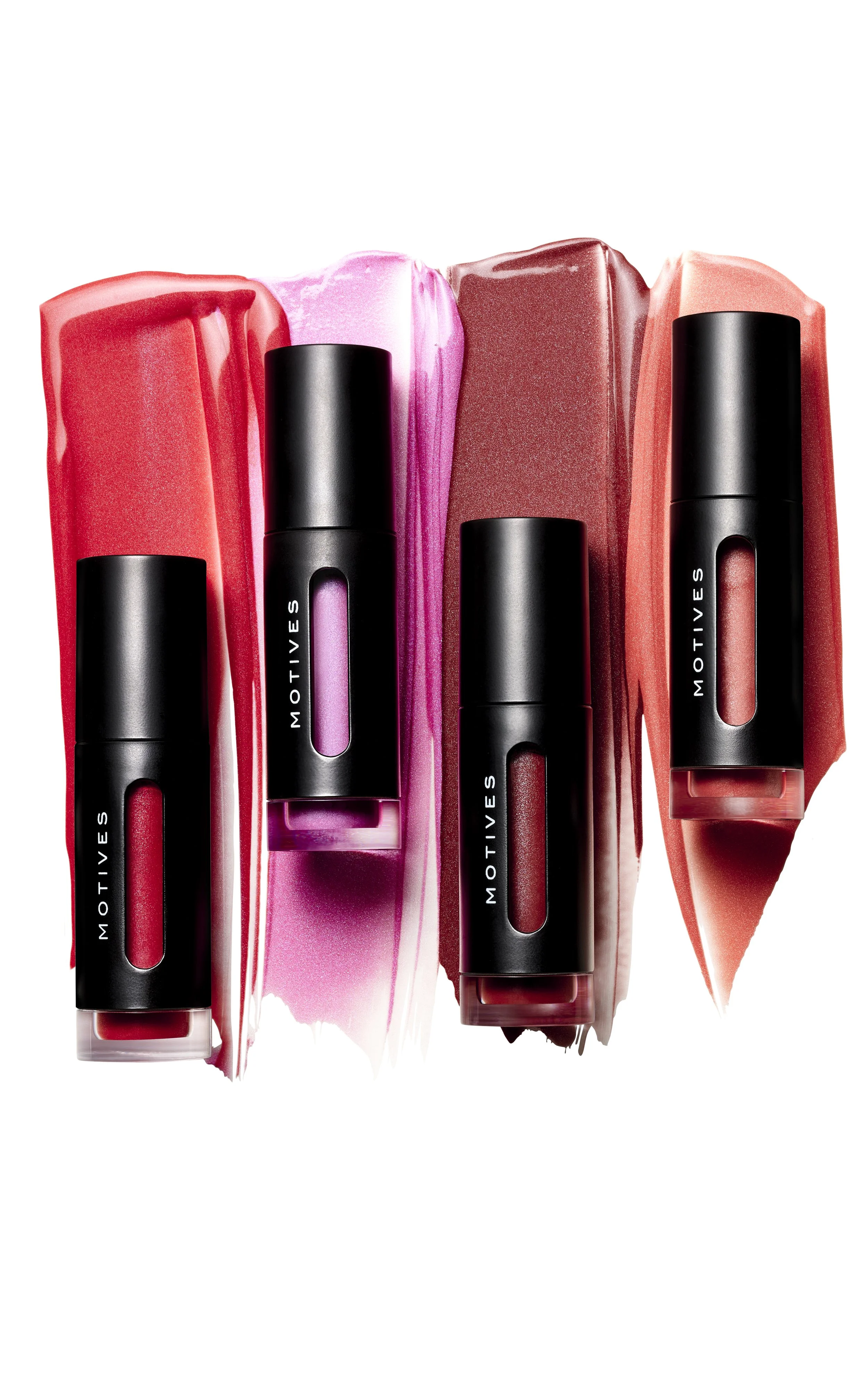 Four lipstick tubes with black caps and see-through windows, placed on colorful lipstick smears in shades of pink, red, and coral.
