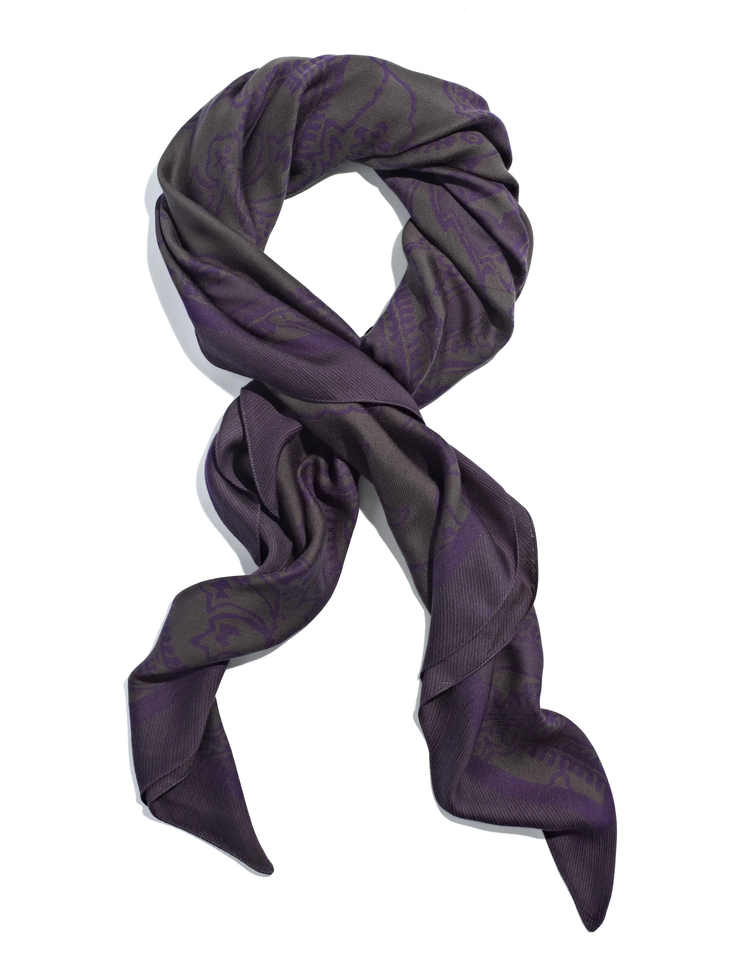 Purple and gray patterned silk scarf folded in a knot, laid on a white background.