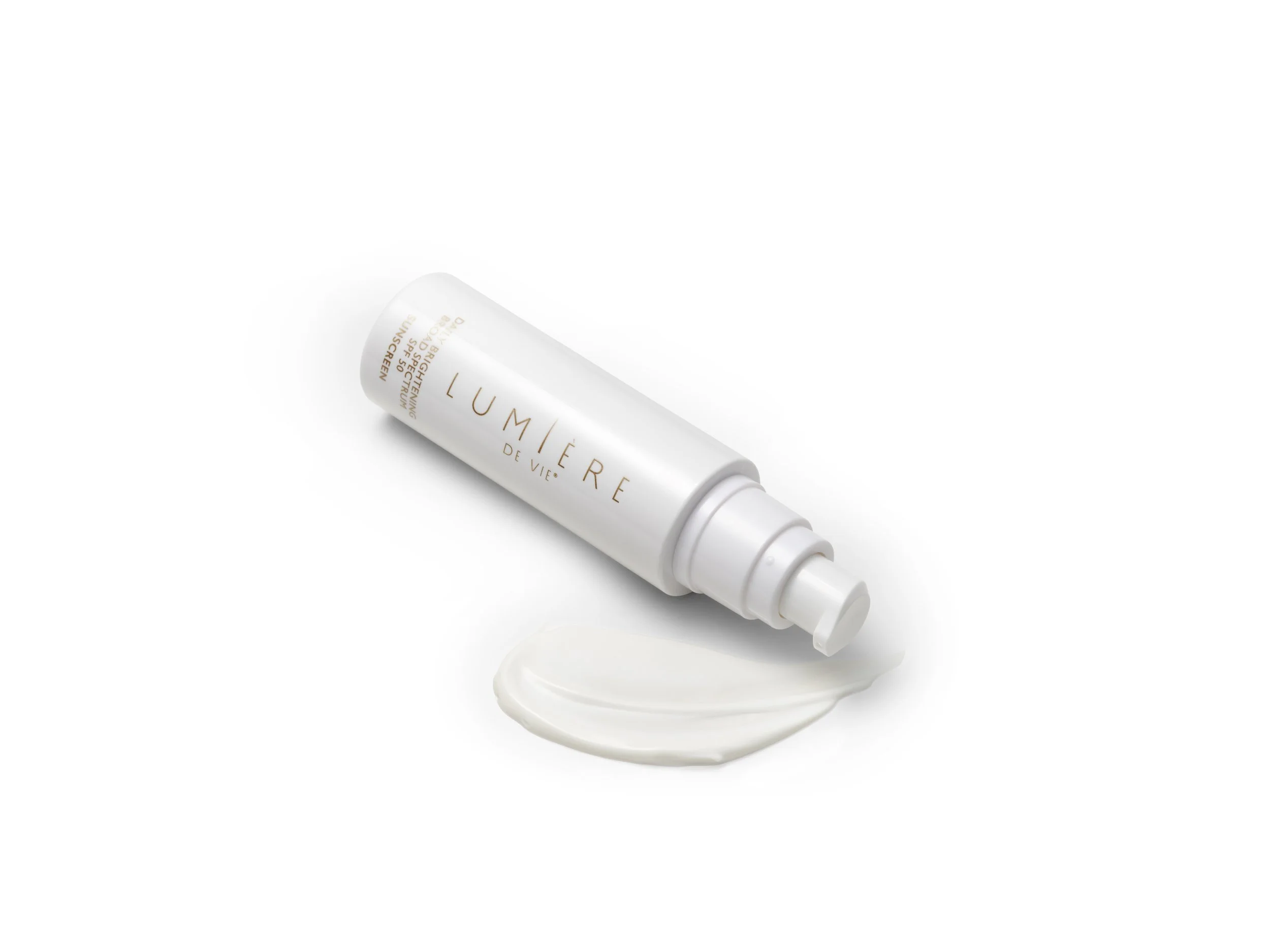 A white bottle with a nozzle, labeled 'LUMIÈRE DE VIE,' lying on a white surface with a dollop of cream in front of it.