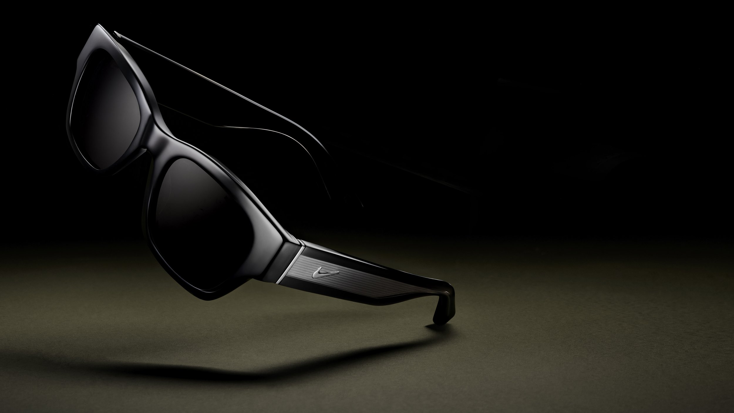 Black Nike-branded sunglasses on a dark background