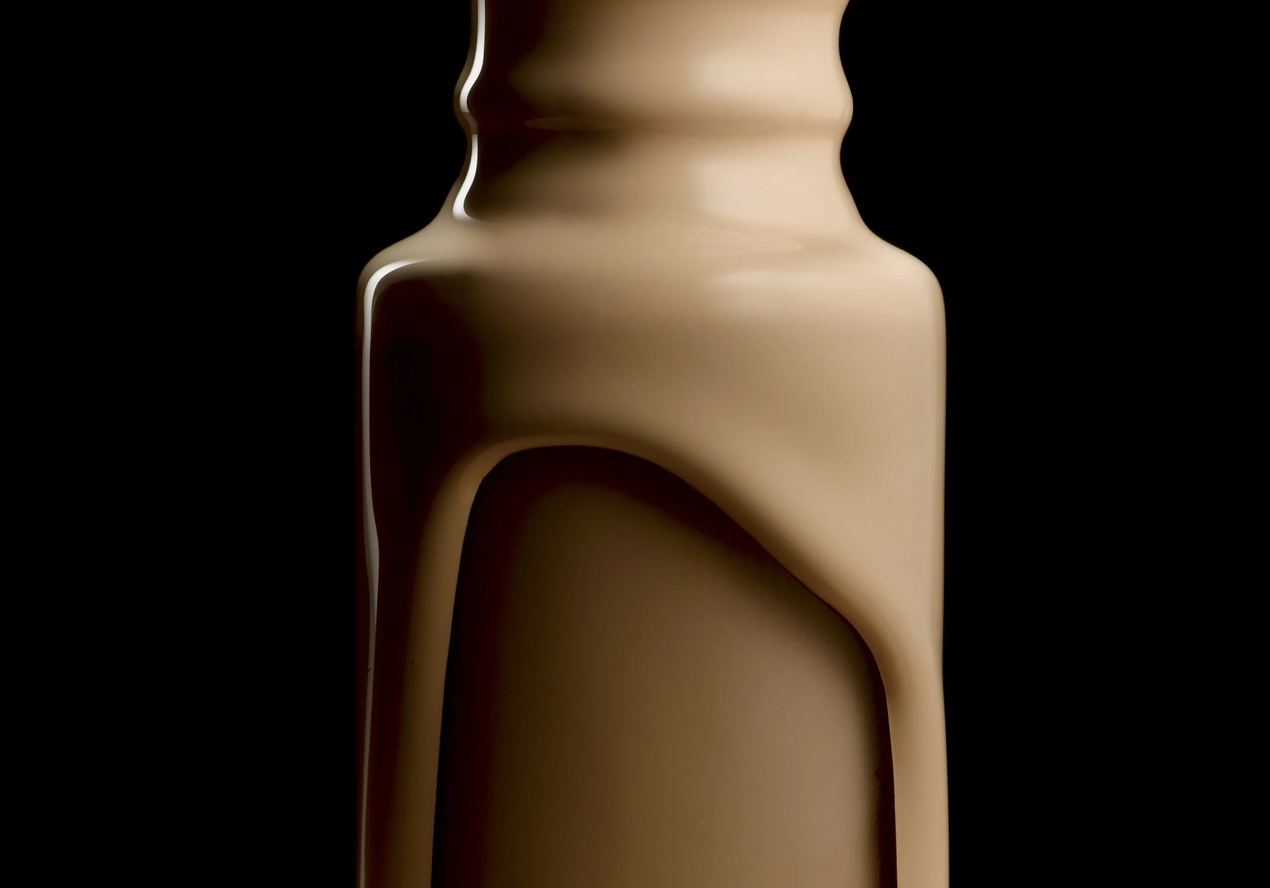 Close-up of a beige, modern, curved ceramic vase against a black background.