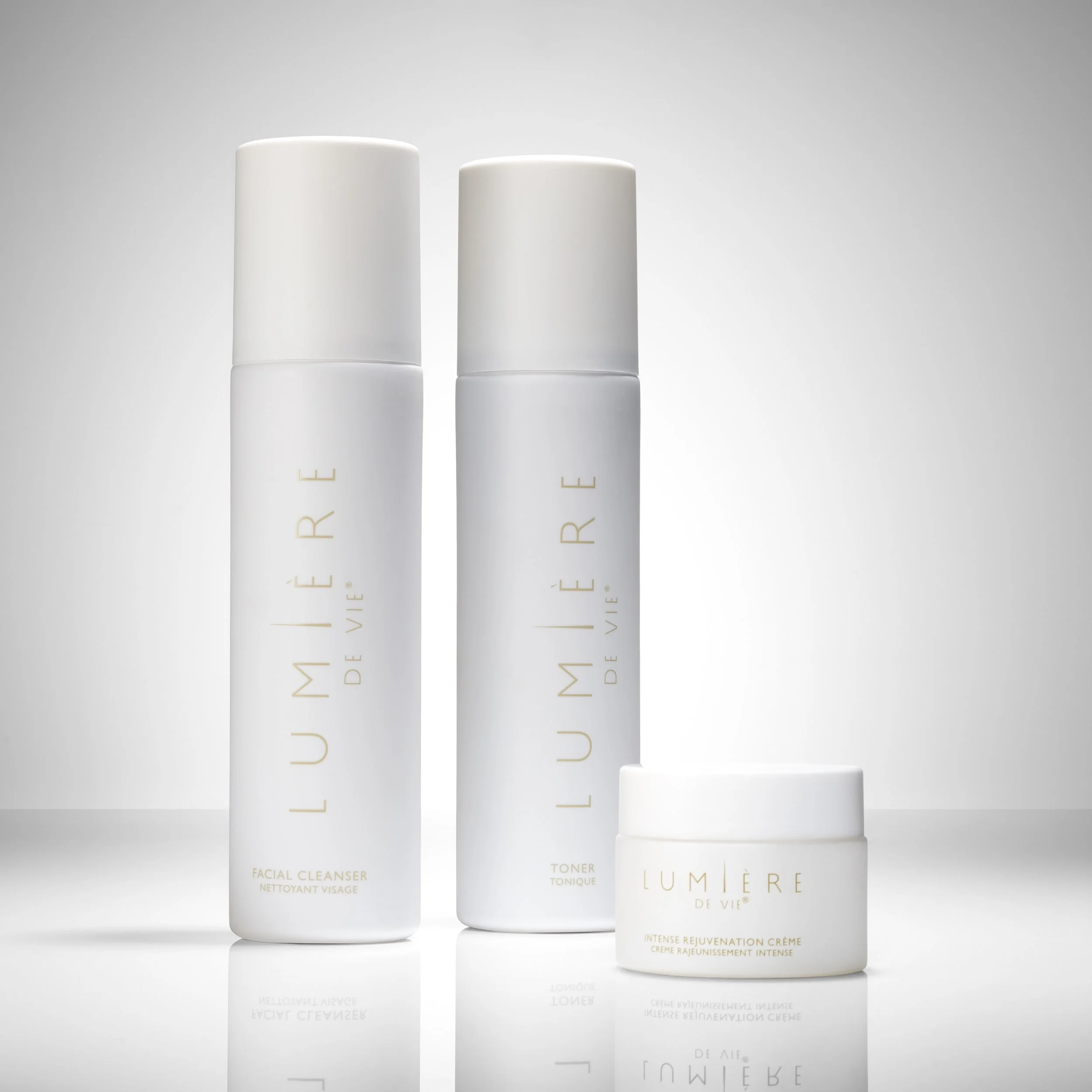 Three white skincare product containers from Lumière de Vie, including a facial cleanser, toner, and rejuvenation cream, displayed against a light gray background.