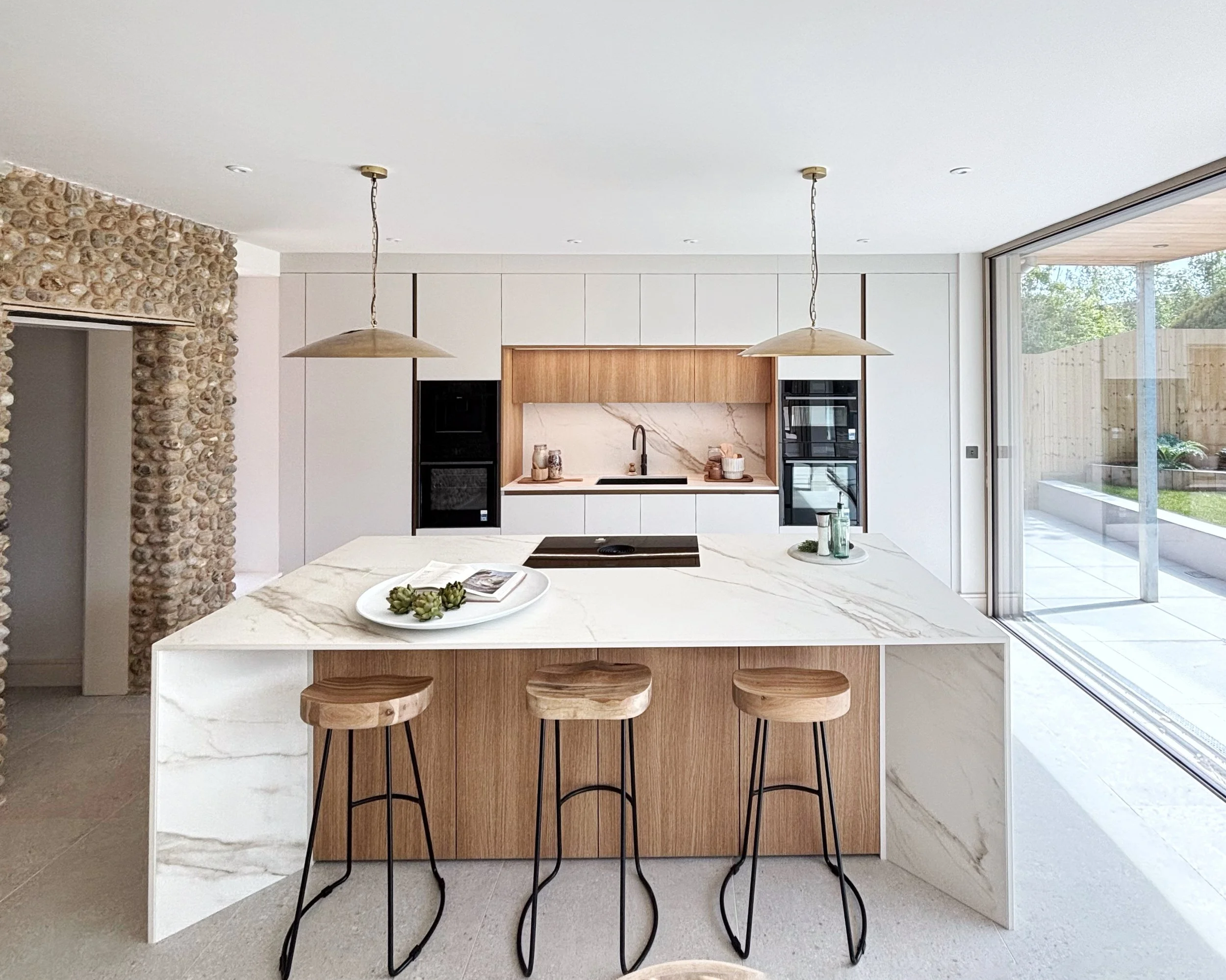 View of statement island and kitchen behind