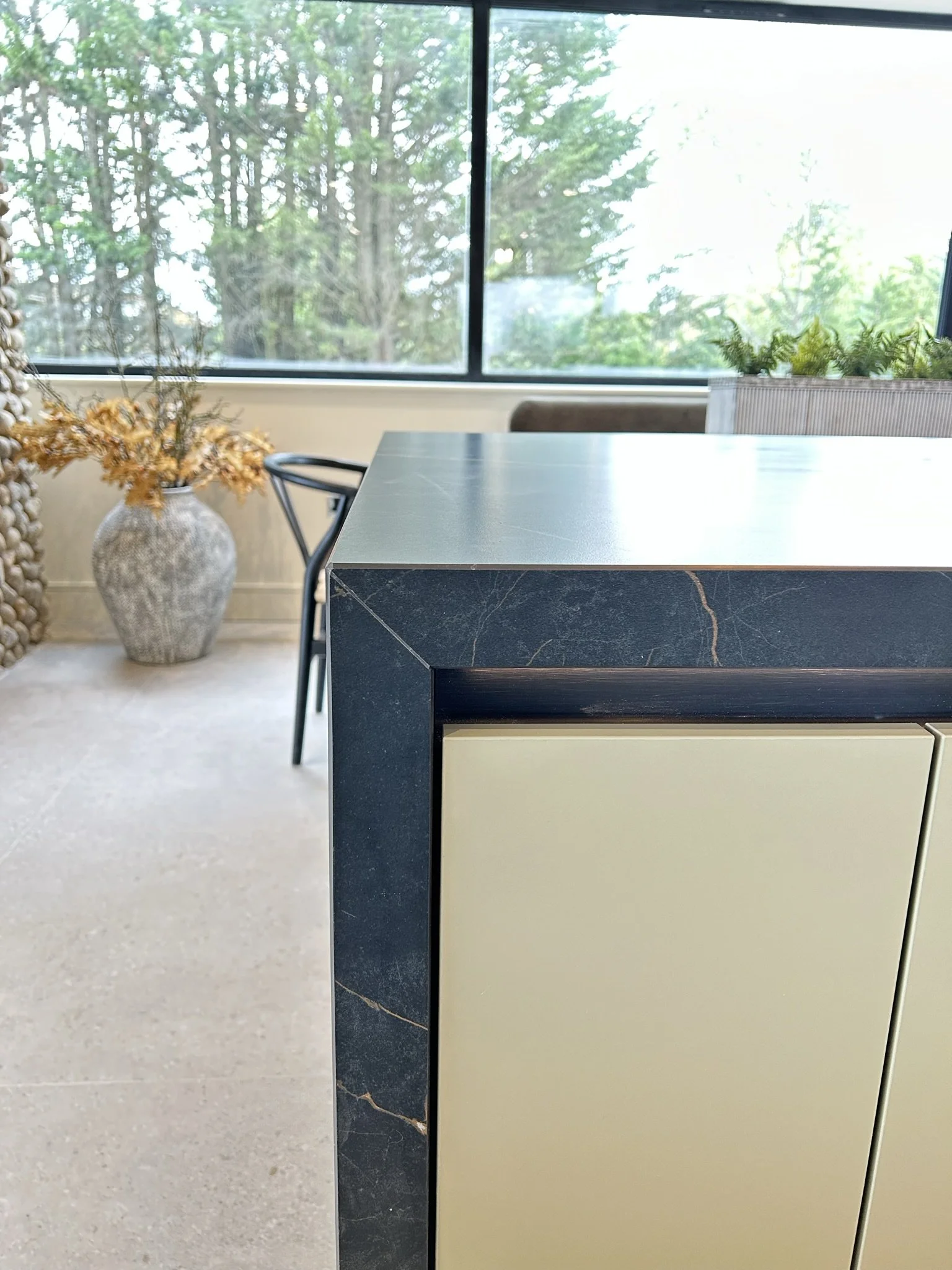 View of mitred built up ceramic worktop in dark colour with honey and white veins