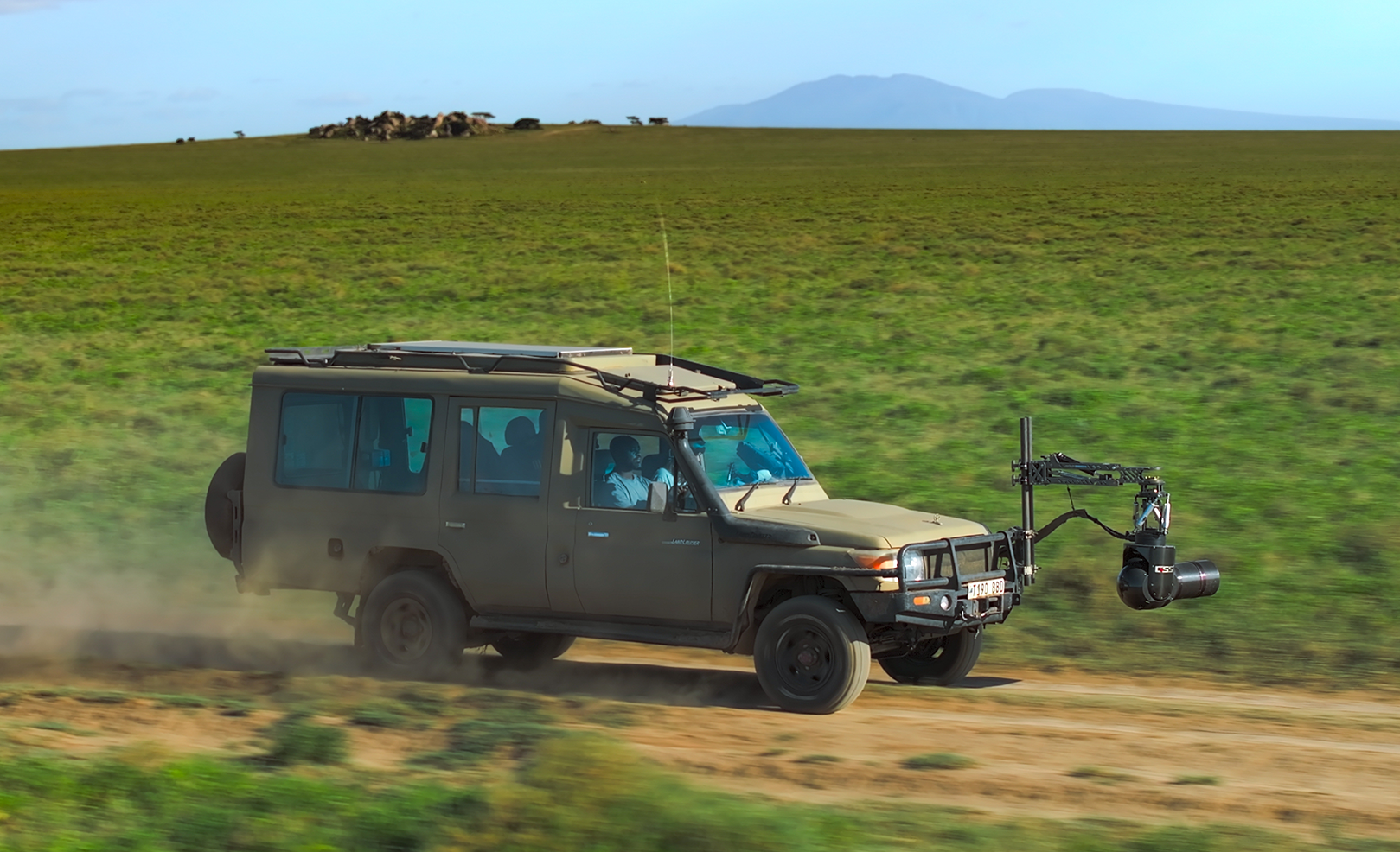 A safari Jeep speeds along filming wildlife through it's attached GSS camera. (credit: National Geographic/Bertie Gregory)