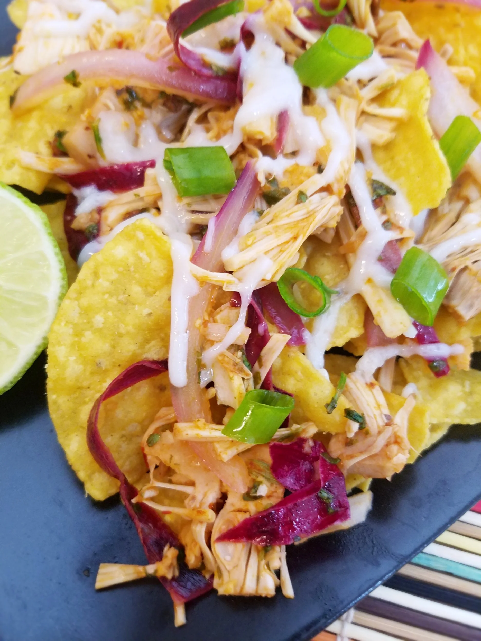 Served on top of tortilla chips with a bit of shredded vegan cheese and some scallions. Yum!