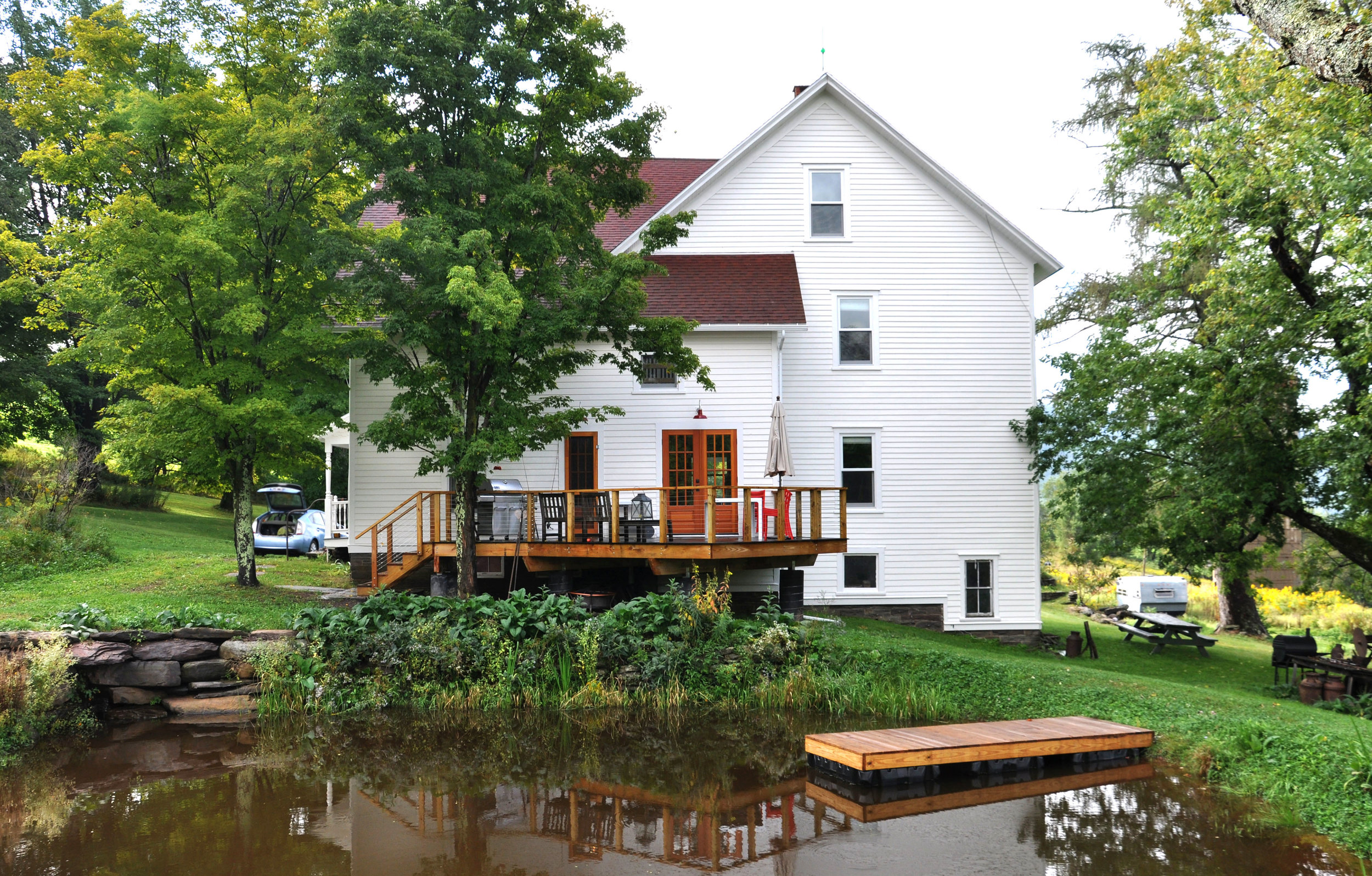 modernized rural farmhouse, residential renovation, deck, porch, outdoor dining, mountain home, pond