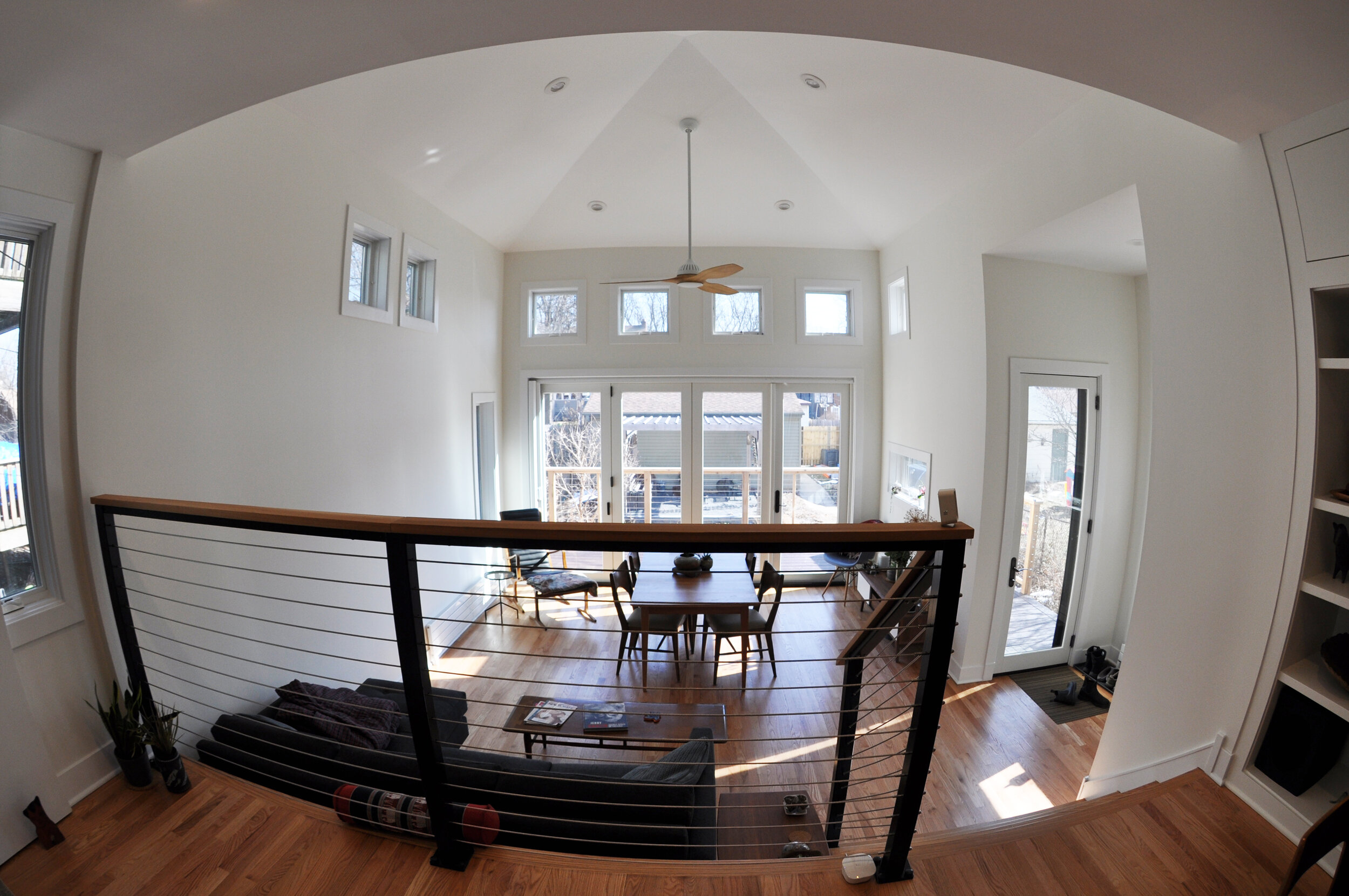 fisheye view of living space with tall ceilings, french doors, many windows, hardwood floors