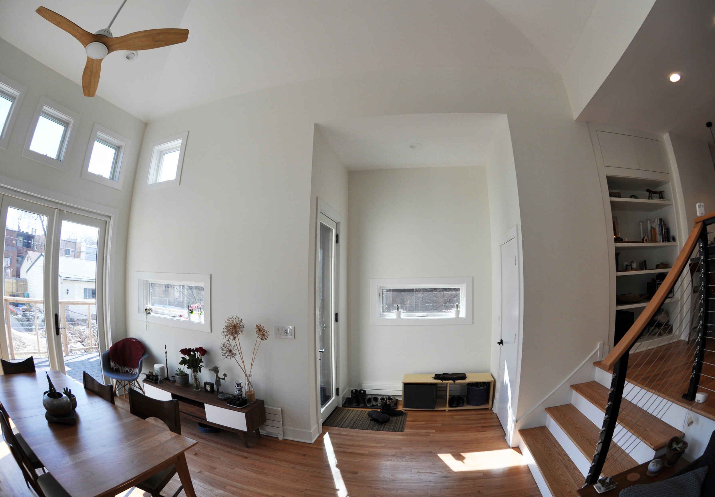 fisheye view of living space with tall ceilings, french doors, many windows