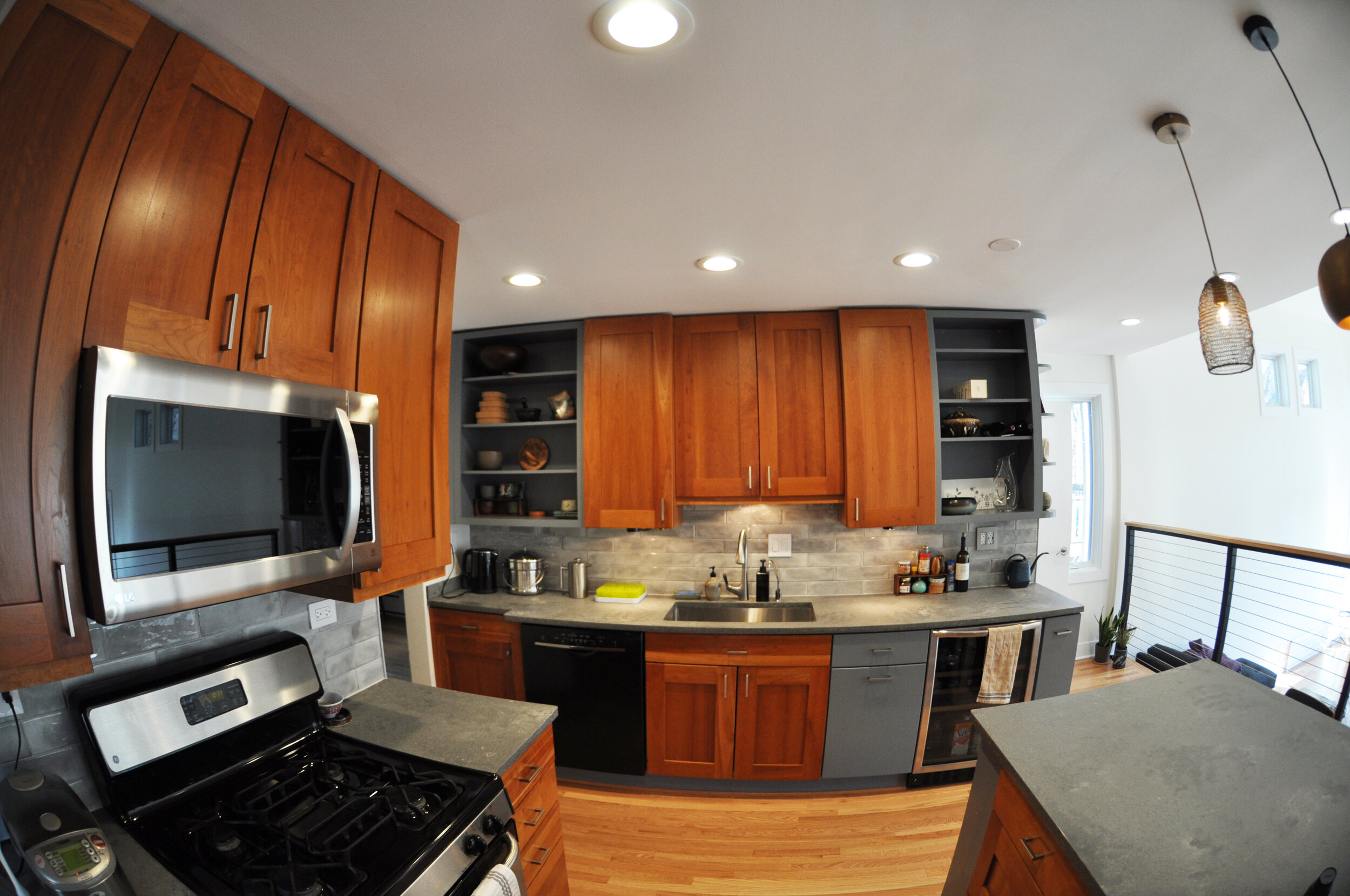 fisheye view of renovated kitchen with hardwood floors and grey and wood cabinets