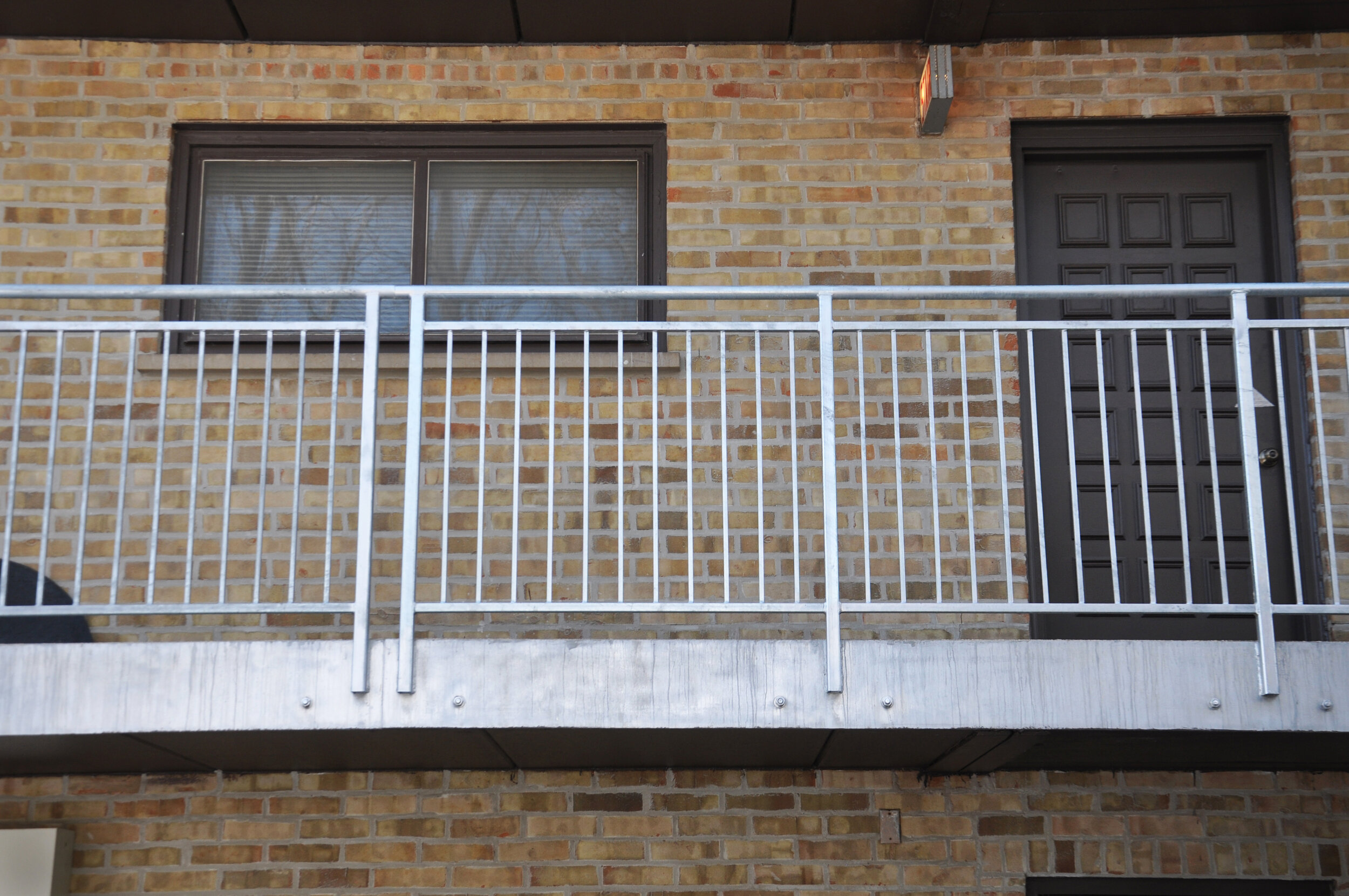 multi-family residential condominium building with new railings and railing support system