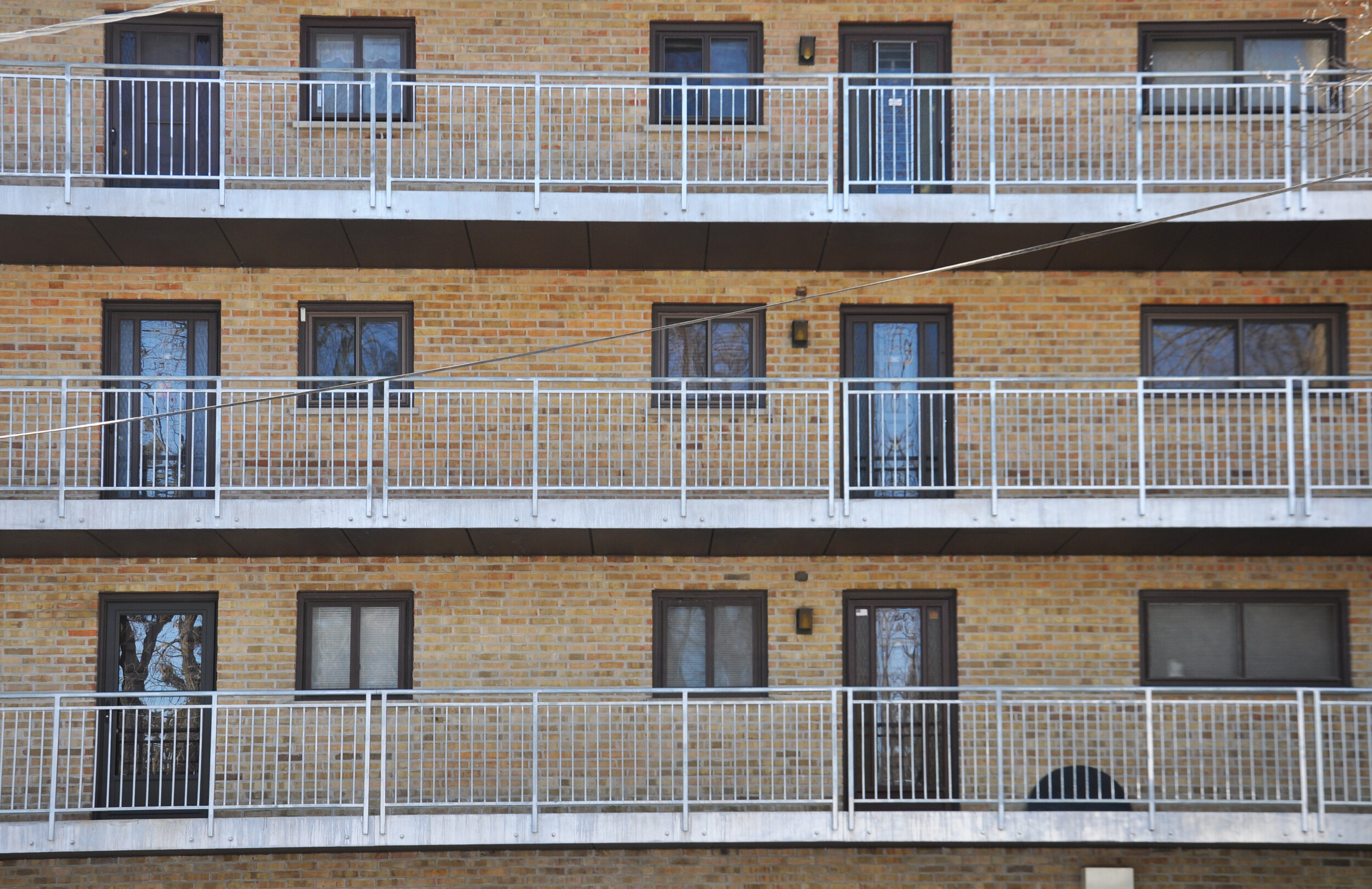 multi-family residential condominium building with new railings and railing support system