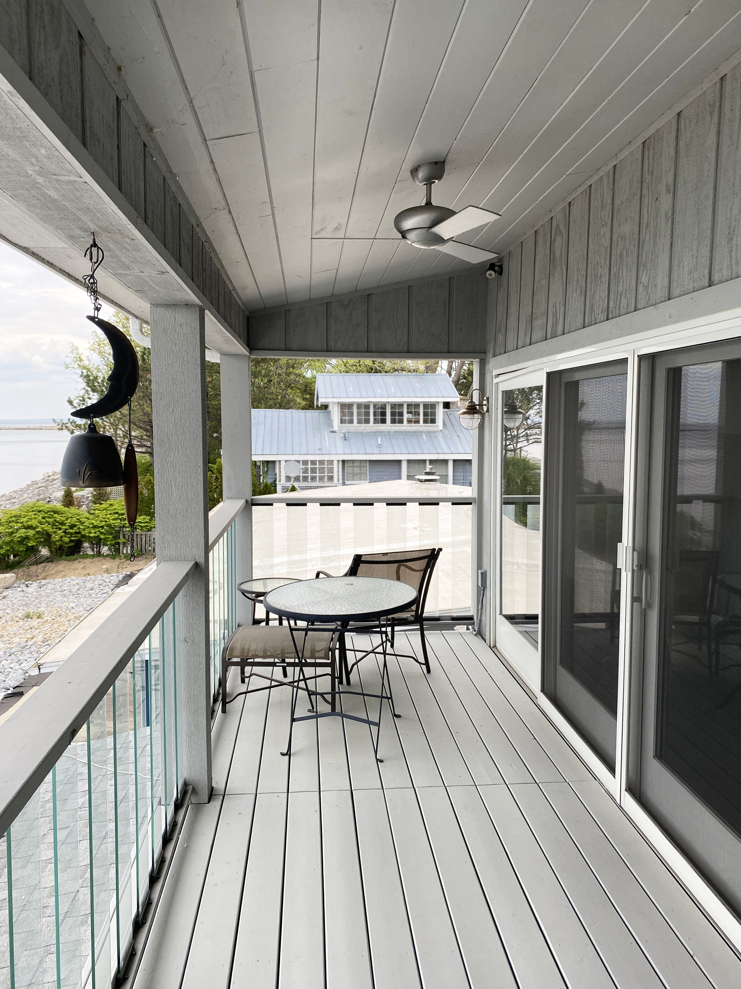 porch with wall of sliding glass doors and glass railing on 2nd floor addition on a residential beach house