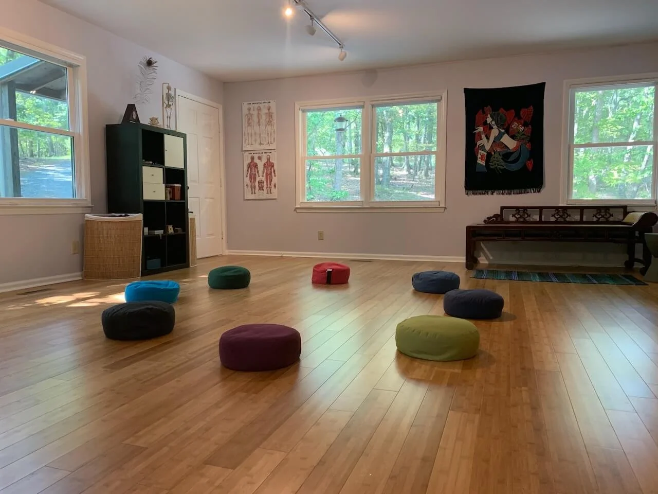 Meditation cushions arranged in a circle on a wooden floor.