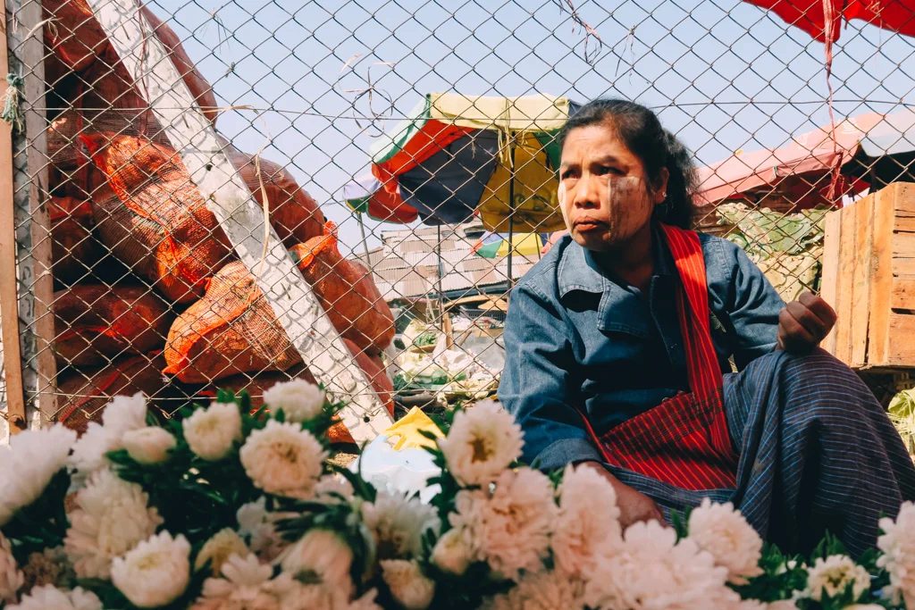 A woman sells flowers at a train station in Yangon, Myanmar