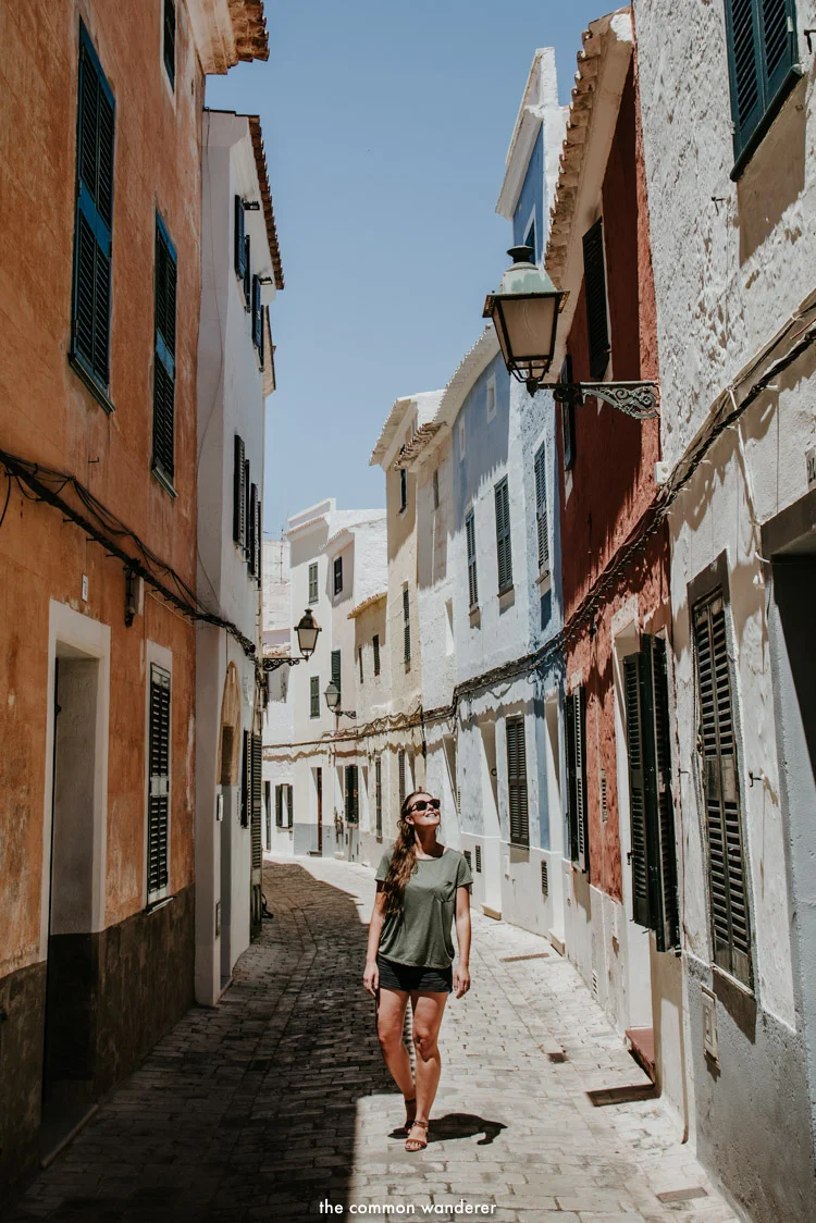 A woman walks down the colourful streets of Ciutadella, Menorca