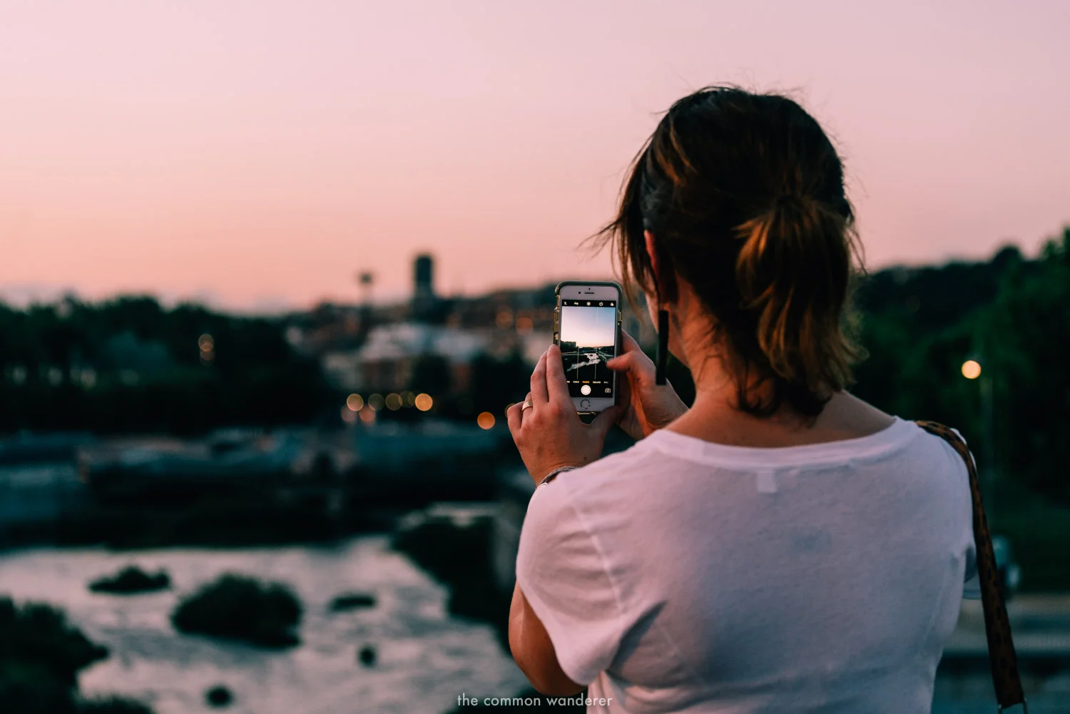 A woman takes a photo on her smartphone over Madrid, Spain